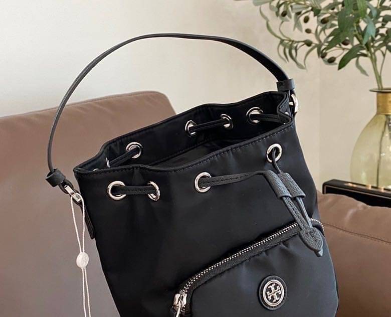 Tory Burch Virginia Nylon Bucket Bag / Tory Burch logo-plaque bucket bag กระเป๋าสะพายทรงบัคเก็ต เปิด-ปิดหนังรูดปากกระเป๋า มีหูหิ้วในตัว คล้องแขนเก๋ๆ ภายในเป็นช่องโล่ง มีช่องย่อย ใส่ของสำคัญจุกจิกได้ มีสายครอส จะสะพายไปไหนก็ได้ทุกโอกาส สวยเลิศทุกสี พร้อมส่