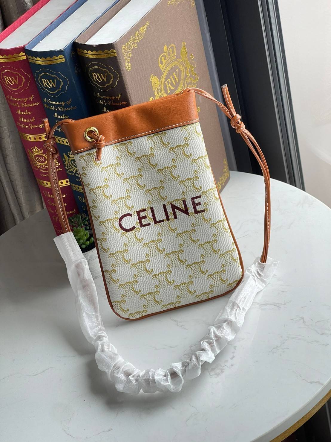 Celine Triomphe Pouch Crossbody Bag / Celine Phone Bag ในวันที่ต้องการความคล่องตัว เราสามารถหยิบกระเป๋าใส่โทรศัพท์ประเภทนี้เพื่อใส่เพียงแค่โทรศัพท์ เงิน และของสำคัญชิ้นเล็ก ๆ ได้เลย โดยไม่ต้องพกกระเป๋าใบใหญ่ ๆ ไปให้เกะกะ แถมยังดูเป็นแฟชั่นที่ทันสมัยอีกด้ว