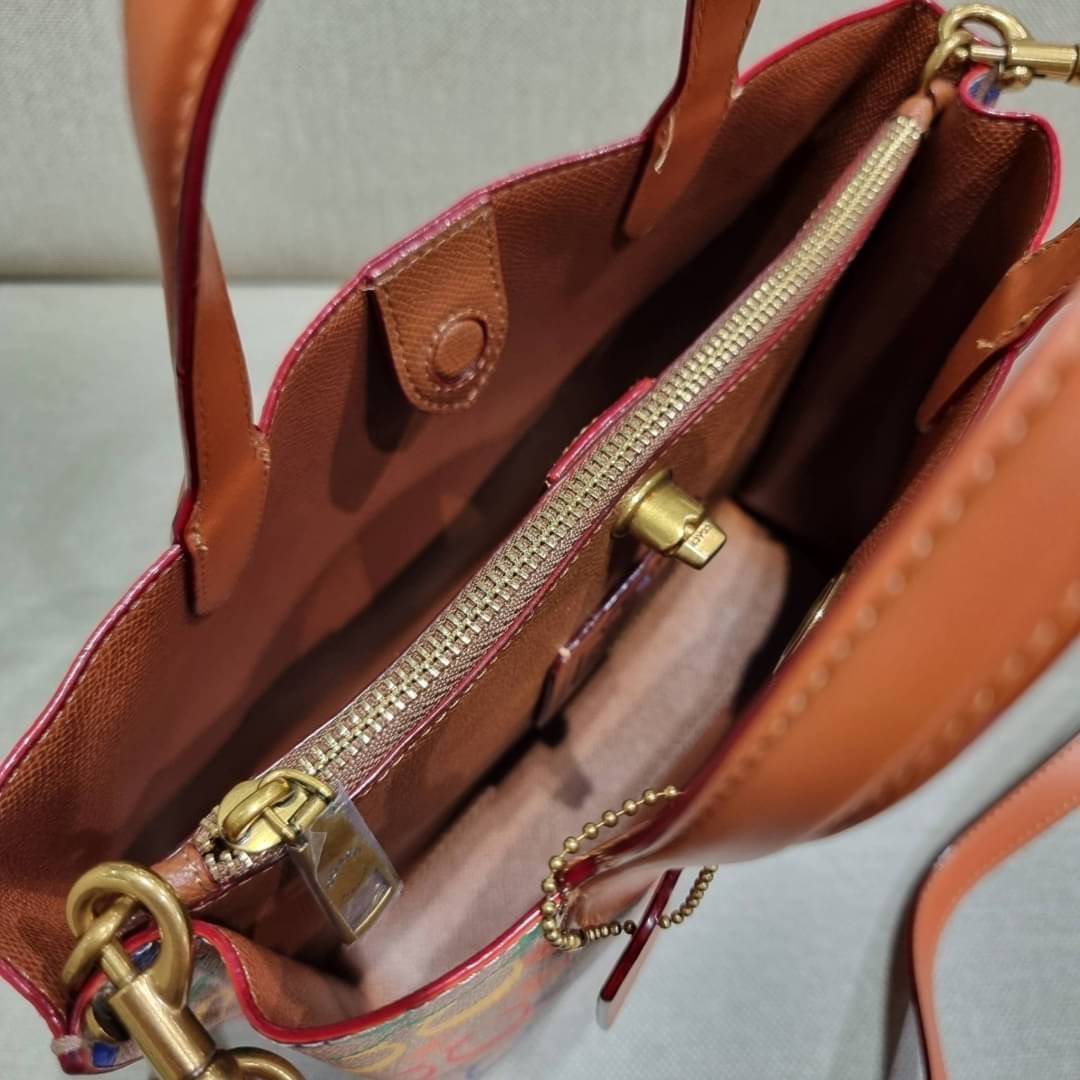 COACH CA102 WILLOW TOTE 24 IN RAINBOW SIGNATURE CANVAS ไปให้สุดกับความเลิศของลวดลายสายรุ้ง ที่แต่งแต้มลงบนกระเป๋าทรงโท้ท ไซส์กำลังสวย พกพาได้สะดวก มีตัวบิดล็อคที่ปากกระเป๋าด้านหนึ่ง และกระดุมแม่เหล็กอีกด้านหนึ่ง ภายในโล่งกว้าง เก็บของได้เป็นสัดส่วนไปเลย ม