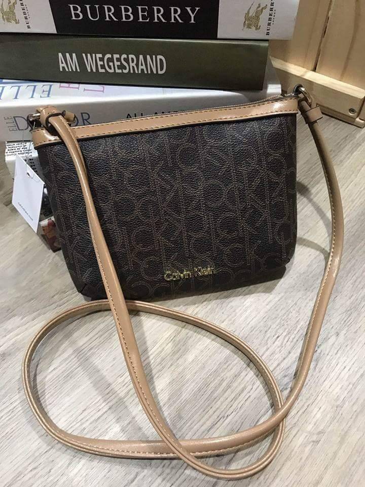 Calvin Klein Cross Body Bag กระเป๋าสะพายรุ่นใหม่ล่าสุดหนังสวย สกรีนลาย Signature แบรนด์รอบใบ ประดับโลโก้แบรนด์ สีทองด้านหน้า เปิดปิดด้วยซิป น้ำหนักเบา ภายใน โล่งกว้าง มีช่องใส่บัตร และช่องซิป ใส่ iphone+ ได้ มาพร้อมสายสะพายยาว ขนาดกำลังน่ารัก สะพายคล่องตั