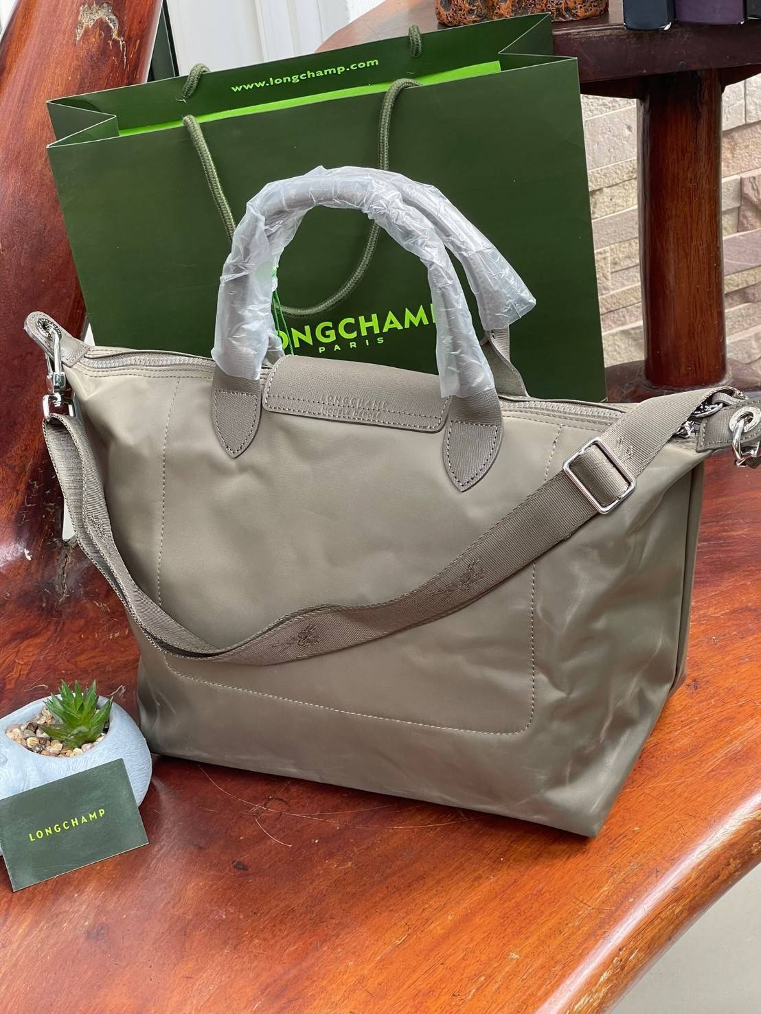 Longchamp LE PLIAGE NÉO TOP HANDLE BAG อีกหนึ่งรุ่นยอดนิยม ที่สาวๆ ต้องมีไว้เก็บไว้สักใบ กระเป๋าโท้ทใบนี้ มาพร้อมกับสีที่มีสไตล์เรียบง่าย มีสายสะพายยาวปรับสั้นยาวได้ช่วยให้คุณสามารถสะพายไหล่ได้อย่างสบาย ในตัวสายปักโลโก้อันเป็นสัญลักษณ์ ในขณะที่ที่ปิดแบบซิ