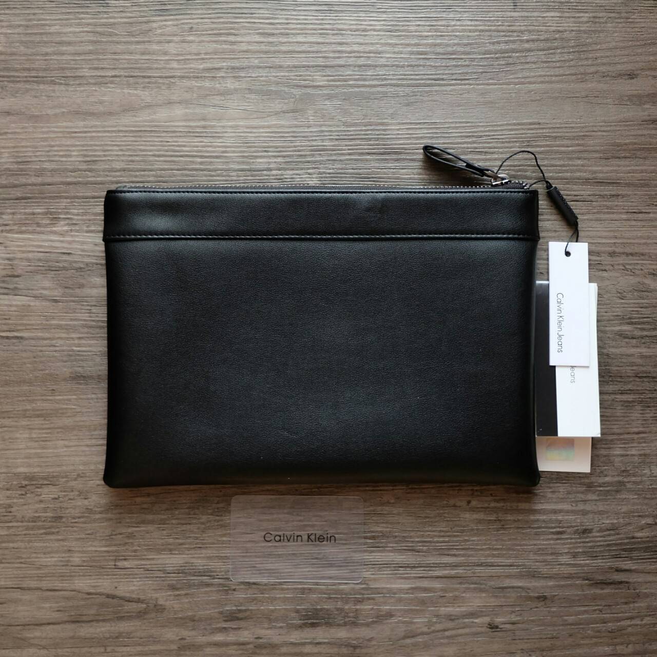 Cluth Bag Calvin Klein Cluth Bag กระเป๋าถือ ทรงคลัทช์ จากแบรนด์ Calvin Klein ด้านหน้า ปั๊มโลโก้แบรนด์ เปิด - ปิดกระเป๋าด้วยซิป ด้านในแบ่งเก็บของ ได้ 2 ช่องใหญ่ และมีช่องใส่บัตร 1 ช่อง สามารถใส่ iPad Mini ได้ค่ะ