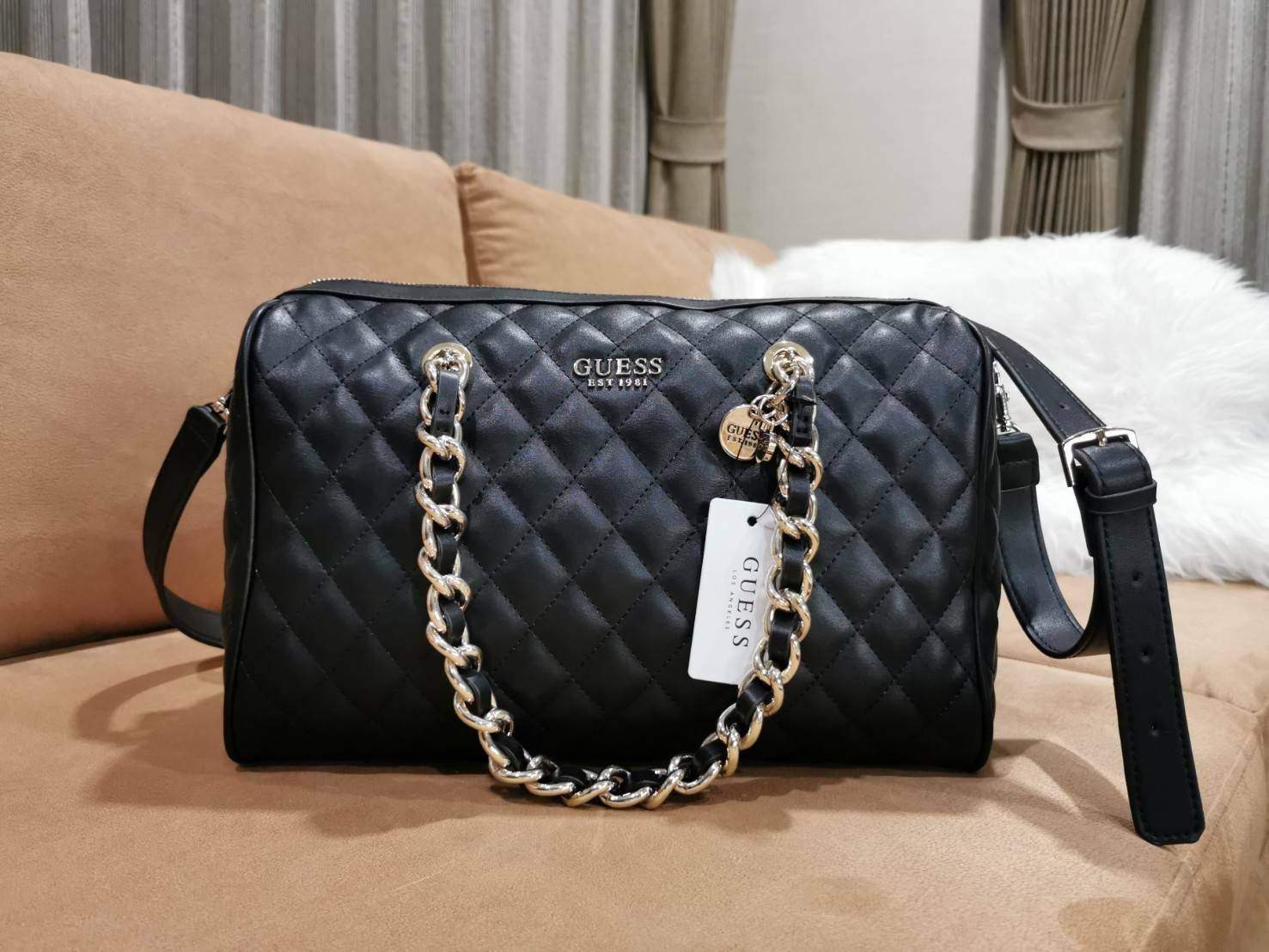 GUESS WOMEN’S BOWLING BAG กระเป๋าสะพายทรง Bowling รุ่นใหม่ล่าสุดจาก GUESS FACTORY หนังนิ่มลายตารางสวยอยู่ทรงใบใหญ่กำลังดี ด้านหน้าประดับโลโก้หูหิ้วโซ่ร้อยหนังสะพายไหล่ได้เเข็งแรงรับน้ำหนักได้เยอะ เปิดปิดด้วยซิปสะดวกใช้ มีหมุดรองฐานกันรอย ภายในมีช่องซิปและ