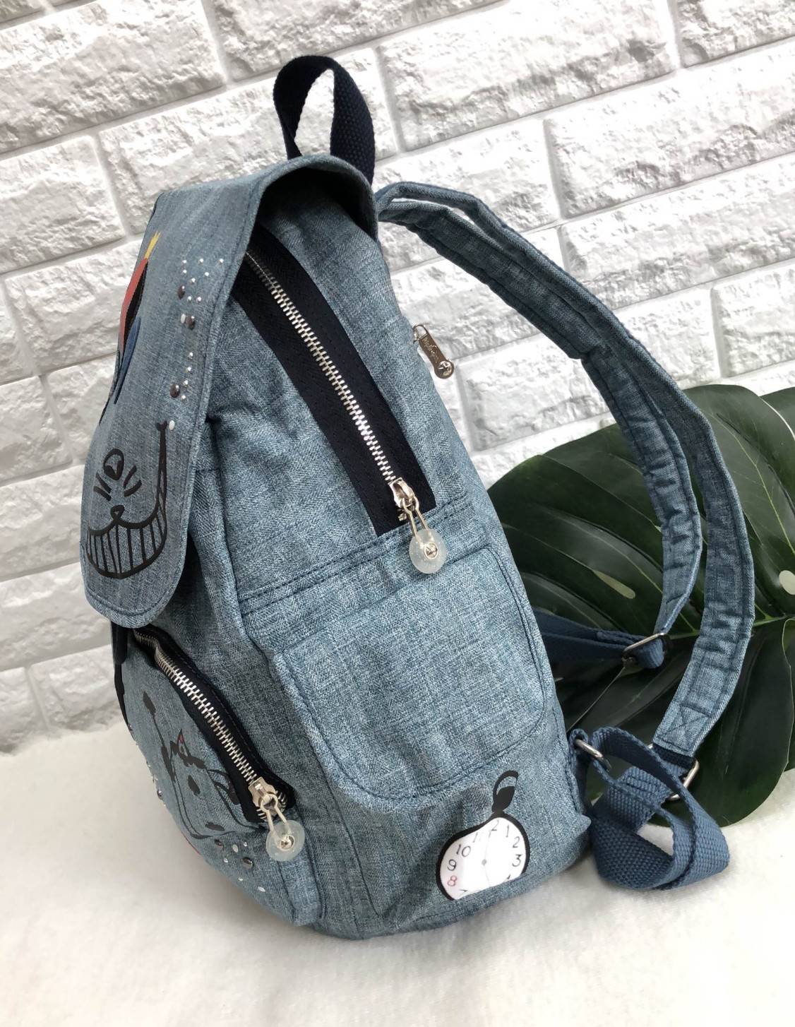 Kipling Disney's Alice in Wonderland Printed Backpack กระเป๋าเป้ Limited คอลเลคชั่น ALICE วัสดุ Denim+Polyester 100% เปิดปิดด้วยฝาปิด กระดุมแม่เหล็ก และซิปรอบ มาพร้อมพวงกุญเเจลิง ถอดเเยกใช้ได้ มีช่องซิปด้านหน้า และด้านหลัง พร้อมช่องใส่ของด้านข้าง 2 ด