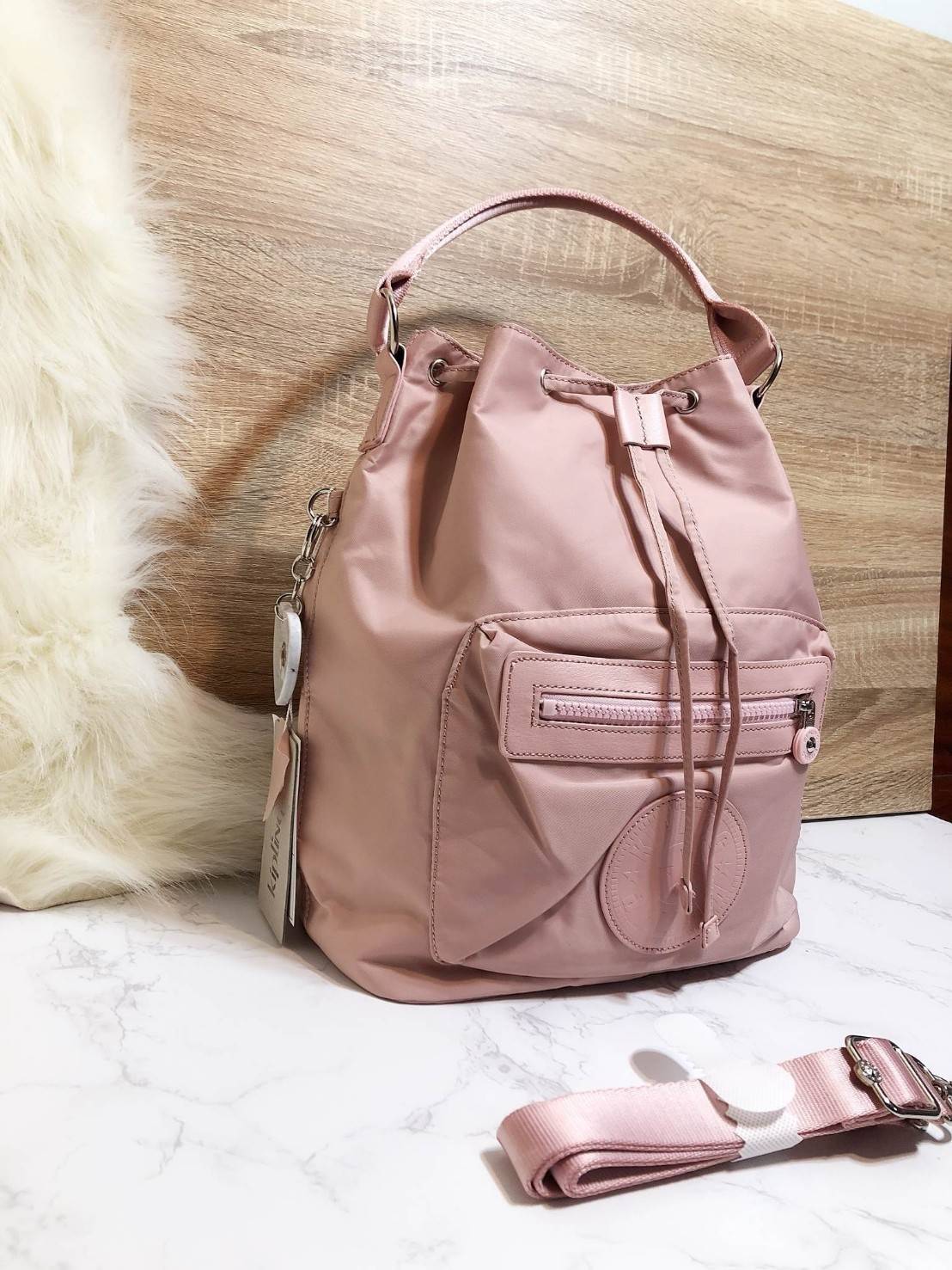 Kipling 2Way Bucket Bag กระเป๋าถือหรือสะพาย 2Way รุ่นใหม่ทรงขนมจีบวัสดุ Nylon & Polyester 100% น้ำหนักเบา ถือและสะพายได้หลายแบบจะใช้สายยาวสะพาย Crossbody หรือใช้สายคู่สะพายหลังแบบเป้ก็ดูดี หูจับถนัดมือสะพายไหล่ได้ เปิดปิดแบบ Drawstring พร้อมกระดุมแม่เหล็ก