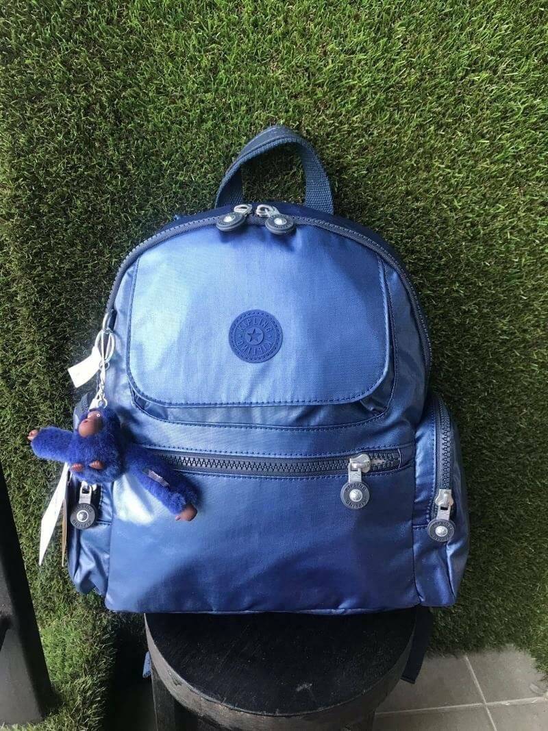 Kipling Matta Small Metallic Backpack กระเป๋าเป้ขนาดกำลังดี วัสดุไนล่อนเคลือบกันน้ำ มีน้ำหนักเบา มีช่องเก็บของหลายช่อง แบ่งเป็นช่องด้านหน้า 2 ช่องและด้านข้างอีก 2 ช่อง ช่องใหญ่ปิดเปิดด้วยซิปคู่ภายในมีช่องซิป ช่องใส่ของจุกจิกและสายห้อยพวงกุญแจ ด้านหน้าประด