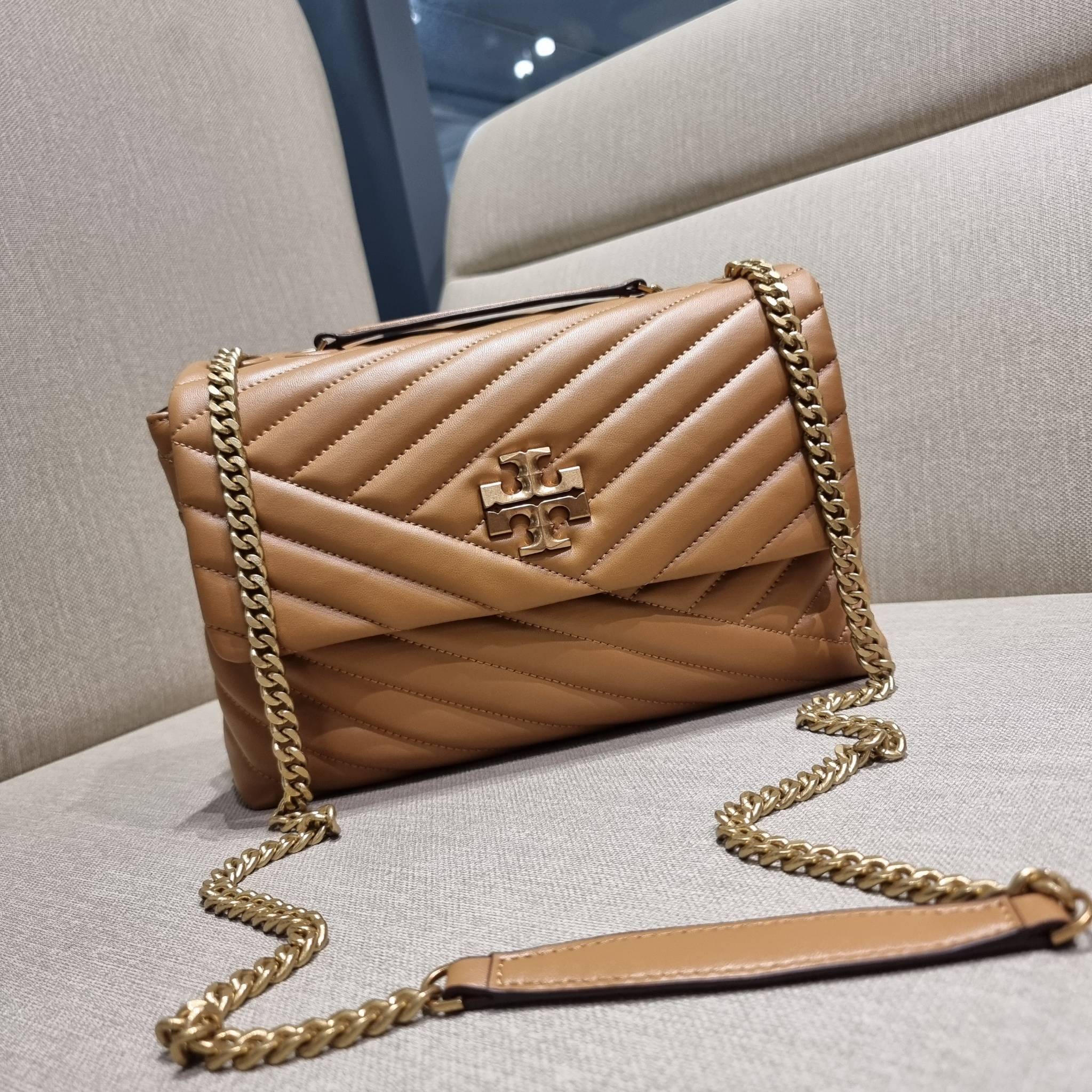 TORY BURCH KIRA CHEVRON CONVERTIBLE SHOULDER BAG กระเป๋าสะพายรุ่นยอดฮิต ไซส์ใหญ่จัดเต็มให้เน้นๆ ใช้ยังไงก็ดูหรู ดีไซน์เฉพาะตัว วัสดุหนังแกะ สัมผัสนิ่ม เปิด-ปิดด้วยกระดุมแม่เหล็ก ภายในเป็นช่องโล่ง แบ่งสัดส่วนไว้ดีมากๆ ใส่กระเป๋าสตางค์ มือถือ เครื่องสำอางค์