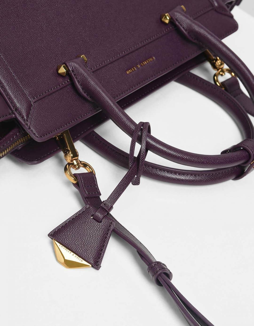 CHARLES & KEITH SAFFIANO TRAPEZE BAG กระเป๋าถือหรือสะพายรุ่นยอดนิยมดีไซน์สวยหรูวัสดุหนังคาเวียร์อยู่ทรง ด้านข้างเเต่งหนังช่องตัดดูมีดีเทล ด้านหน้ามีโลโก้ ด้านหลังมีช่องซิป เปิดปิดด้วยซิปหัวซิปแบรนด์ หูจับเเข็งแรง พับลงได้ พร้อมสายสะพายหนังปรับระดับได้ถอดไ