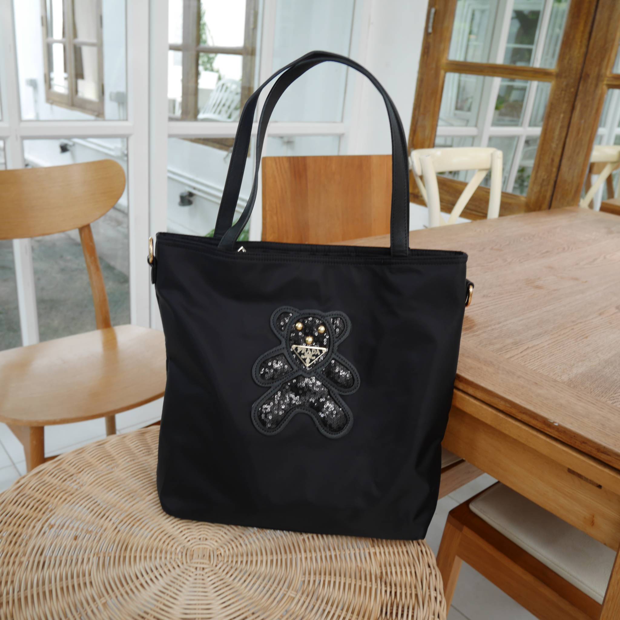 งานขายดีคะ ♡♡ กระเป๋าสะพาย ทรง TOTE จากแบรนด์ PRADA มาค่า ตัวกระเป๋าเป็น nylon ทั้งใบ สะพายเป็น shoulder bag หรือถือได้ค่ะ ด้านหน้าเป็นลายหมี ปักกลิ้ตเตอร์ + logo brand ใช้แล้วสวยมากๆ อะไหล่ทองหรูมาก จุของคุ้ม ใส่หนังสือ หรือ MacBook ได้ค้า 