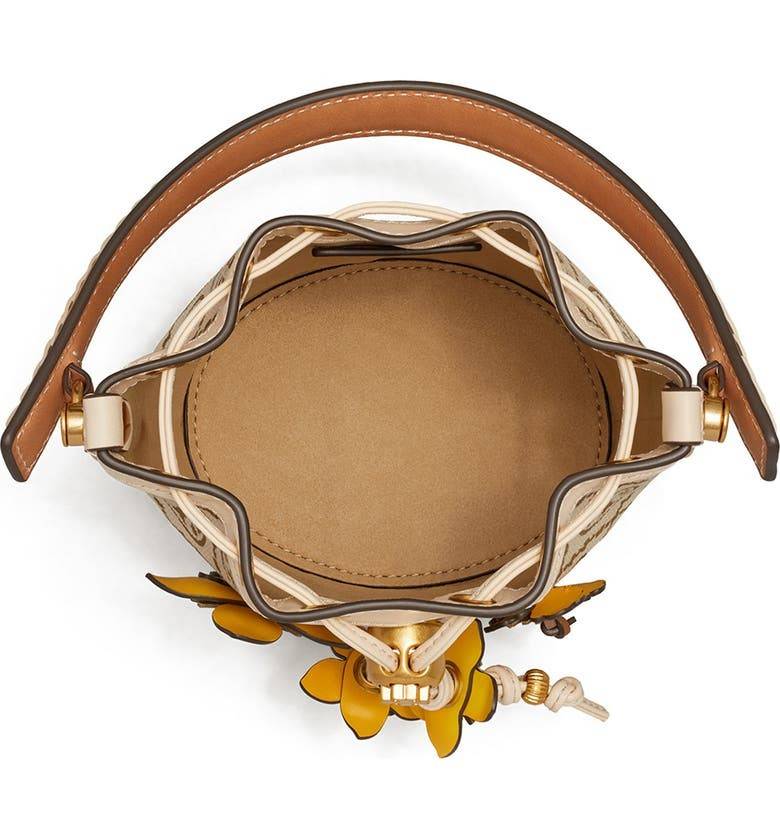 TORY BURCH MINI T MONOGRAM FLORAL BUCKET BAG คอลเลคชั่นใหม่ พร้อมเสิร์ฟความสวยให้ถึงบ้าน!! กระเป๋าบัคเก็ตทรงยอดนิยม ไซส์มินิ ดีไซน์ใหม่ล่าสุด สไตล์งานคราฟ มีลูกเล่นประดับดอกไม้กับตัวกระเป๋า และตัวรูดสาย วัสดุผ้า jacquard ตัดสลับหนังแท้ หูจับและขอบกระเป๋าต