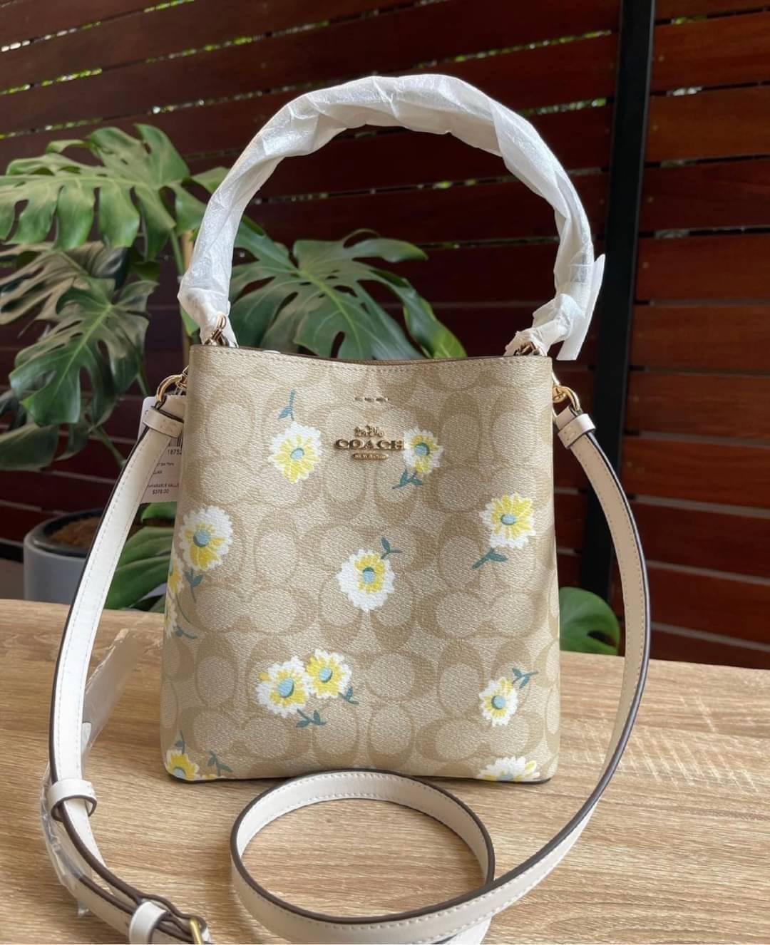 OUTLET 】COACH C3411 SMALL TOWN BUCKET BAG IN SIGNATURE CANVAS WITH DAISY PRINT สวยสดใสมาให้ถึงบ้านจ้า!! กระเป๋าทรงบัคเก็ตยอดฮิต รอบนี้น่ารักมุ้งมิ้งไม่เลิก ดีไซน์ลายดอกเดซี่คละรอบใบ วัสดุหนังแคนวาสเคลือบลาย ปากกระเป๋าเปิด-ปิดด้วยกระดุมแม่เหล็ก 2ฝั่ง มีหูจ