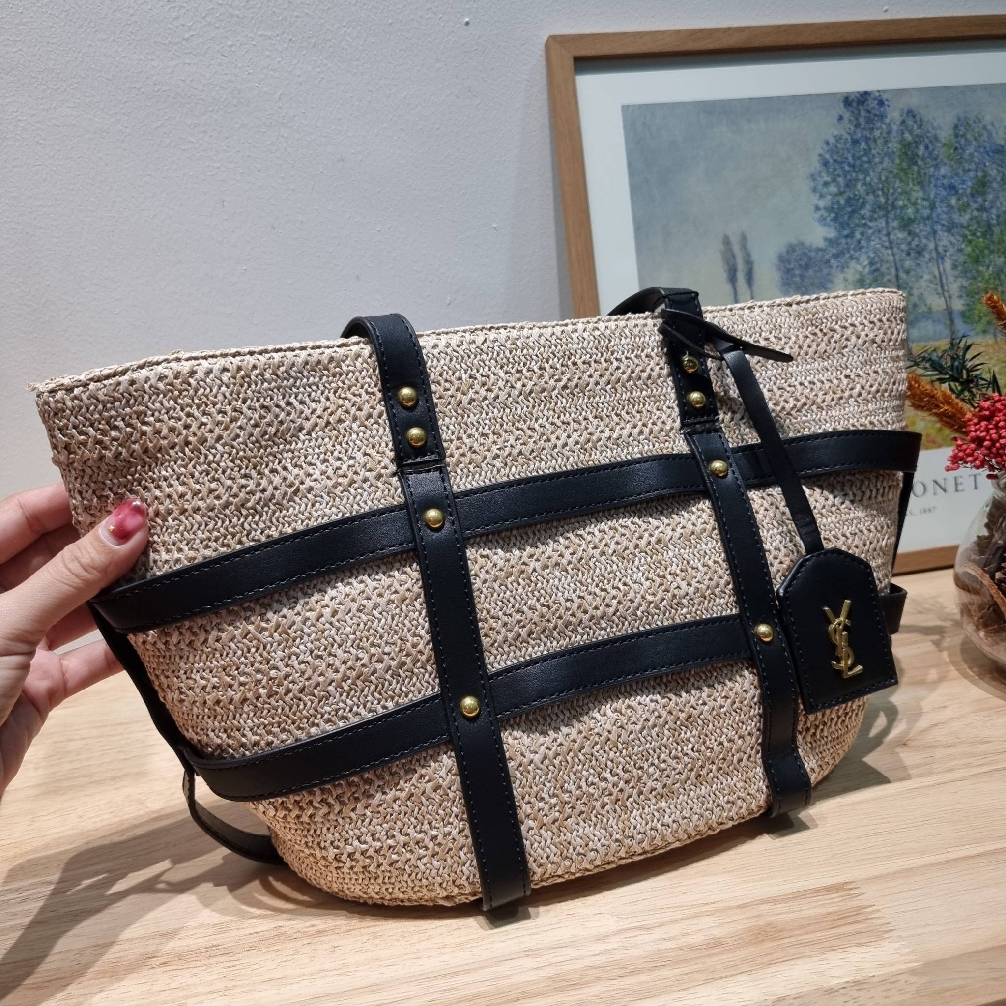 YSL PANIER STUDDED LEATHER TRIMMED WOVEN RAFFIA สวยไม่ซ้ำใคร ใหม่ที่สุด กับกระเป๋าสะพายสานทรงยูนีค ที่เติมดีเทลความหรูด้วยสายหนังคาดตกแต่ง ดูแพงไปอีก