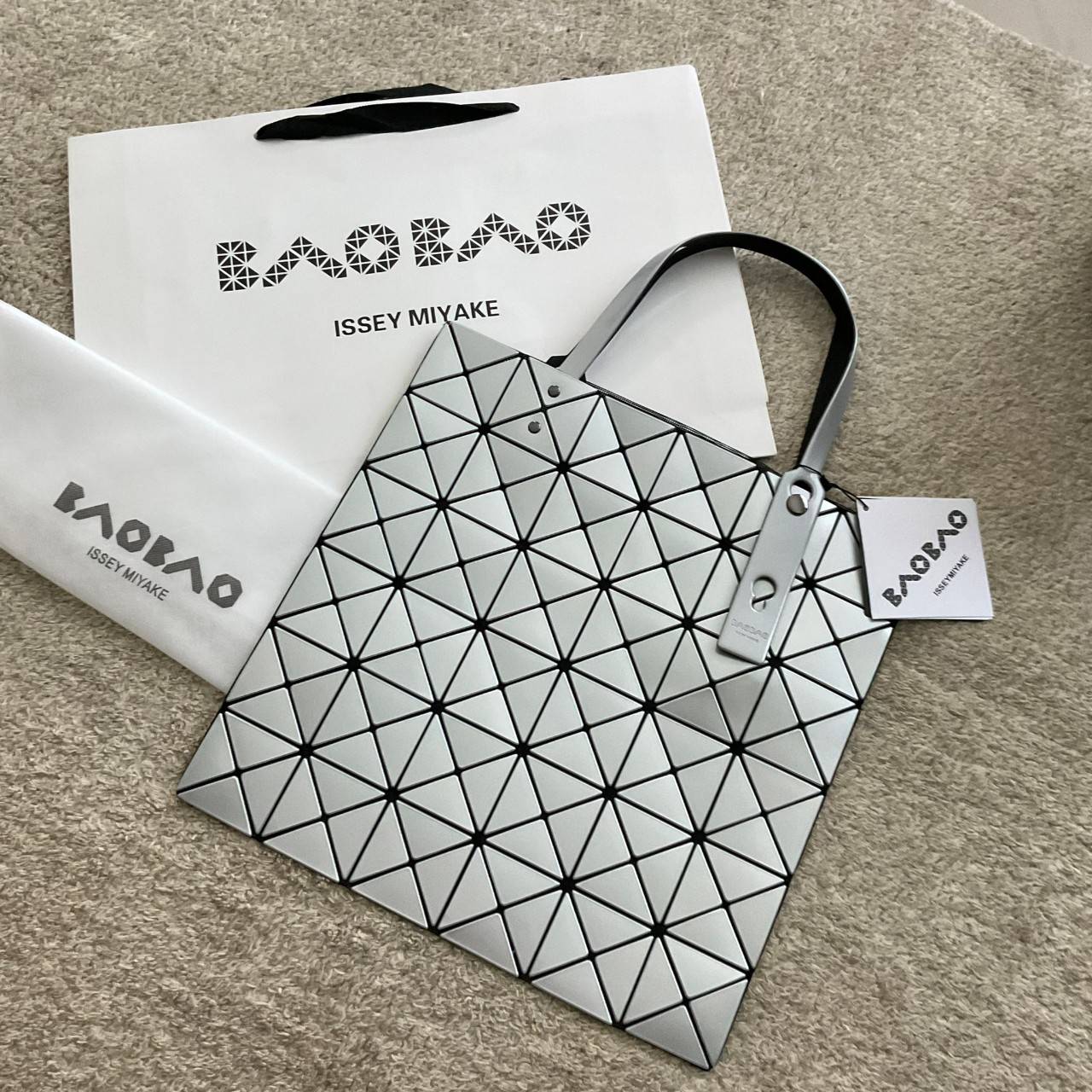 BAO BAO ISSEY MIYAKE TOTE BAG (6x6) กระเป๋าสะพายไหล่ ใบใหญ่ ทรงโท้ท จุดเด่นคือ ปรับได้หลายทรงตามเอกลักษณ์เฉพาะของแบรนด์นี้ ด้านในใส่ของได้เยอะมาก ใส่ไอแพด สมุดโน้ตได้สบายเลย พร้อมช่องซิปใส่ของให้อีกหนึ่งช่อง วัยทำงานหรือวัยนักศึกษา อย่างน้อยต้องมีแบรนด์นี