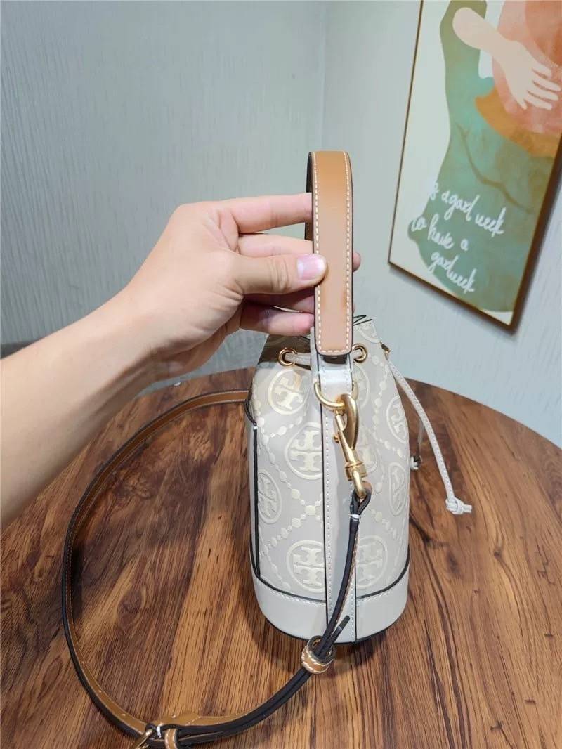 Medium : Tory Burch T Monogram Embossed Bucket Bag กระเป๋าถือหรือสะพายไหล่ ประดับด้วยลวดลายอันเป็นสัญลักษณ์ของแบรนด์ ถูกประดิษขึ้นด้วยความพิถีพิถันวัสดุหนังอย่างดี ด้านในบุด้วยหนังไมโครซูแอคเนื้อนุ่มทำความสะอาดง่าย กระเป๋าผ่าหลังด้านนอก1ช่อง ด้านใน 1ช่อง 