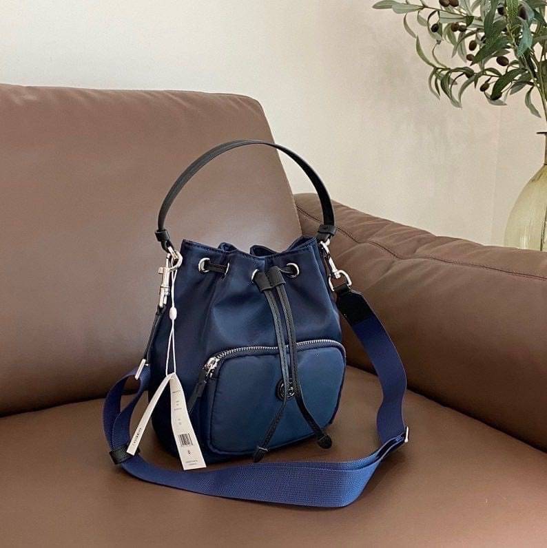 Tory Burch Virginia Nylon Bucket Bag / Tory Burch logo-plaque bucket bag กระเป๋าสะพายทรงบัคเก็ต เปิด-ปิดหนังรูดปากกระเป๋า มีหูหิ้วในตัว คล้องแขนเก๋ๆ ภายในเป็นช่องโล่ง มีช่องย่อย ใส่ของสำคัญจุกจิกได้ มีสายครอส จะสะพายไปไหนก็ได้ทุกโอกาส สวยเลิศทุกสี พร้อมส่