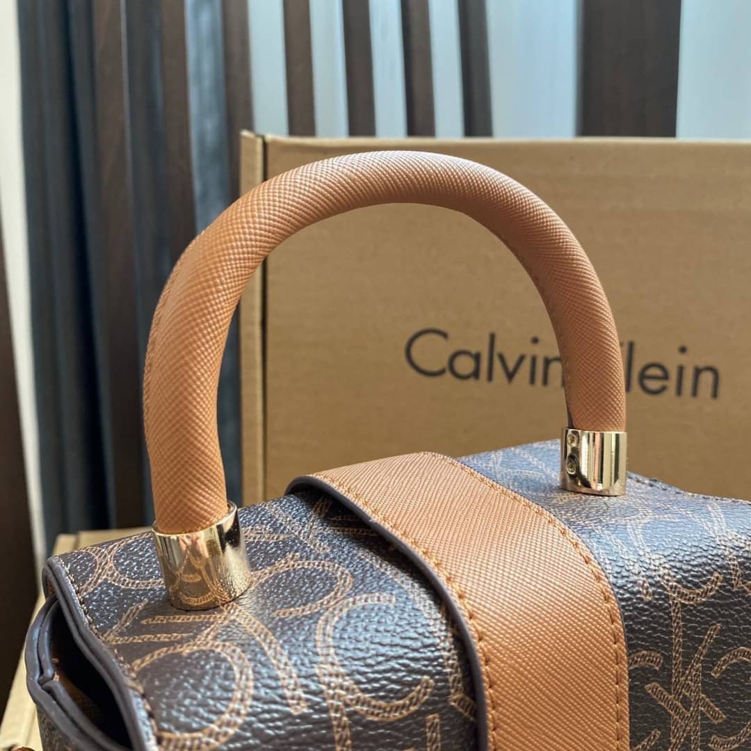 CALVIN KLEIN JEANS crossbody bag กระเป๋าถือหรือสะพาย ลายซิกเนเจอร์แบรนด์ทั้งใบ มีหูจับสำหรับถือ เปิด-ปิดกระเป๋าด้วยกระดุมแม่เหล็ก ด้านในโล่งกว้างมีช่องเล็กและช่องซิปสำหรับใส่ของจุกจิก ซับในลายแบรนด์อย่างดี มาพร้อมสายสะพายยาวปรับระดับได้ สามารถใช้ได้หลากหล