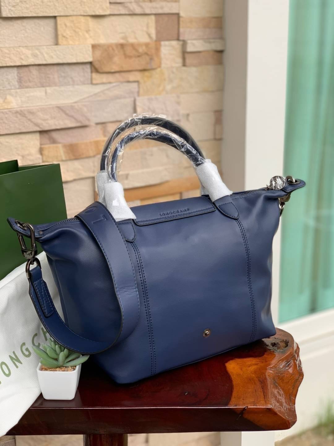 Longchamp LE PLIAGE CUIR TOP HANDLE BAG S เรียกว่าเป็นกระเป๋าอีกหนึ่งรุ่นที่ไม่ว่ายังไงก็ฮอตฮิตและติดเทรนด์ตลอดไม่เคยเปลี่ยนกับ ทรง Le Pliage Cuir หนึ่งในตระกูลกระเป๋าสุดไอคอนิกจากแบรนด์ เมื่อรุ่น Le Pliage Cuir ในรูปแบบของหนังแกะ Metis ได้ถือกำเนิดขึ้นใน