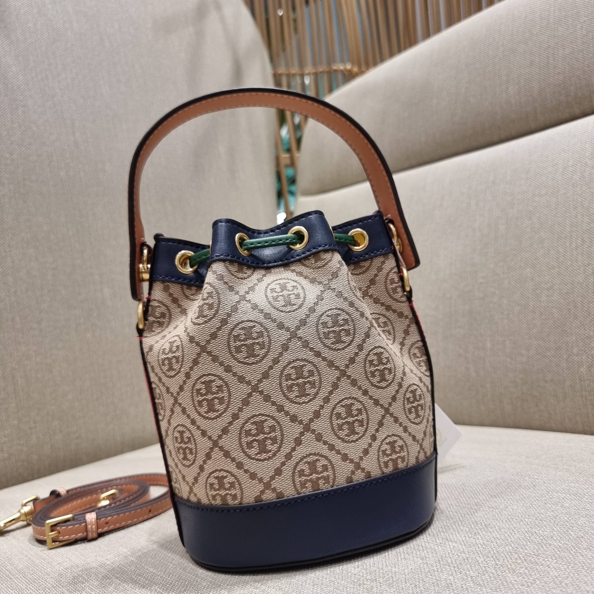 MINI : TORY BURCH T MONOGRAM COLOR-BLOCK JACQUARD MINI BUCKET BAG ใหม่ล่าสุด กับกระเป๋าบัคเก็ตทรงสวย ไซส์มินิ ในราคาน่ารัก โดดเด่นด้วยลวดลายเอกลักษณ์ ผสานลายคัลเลอร์บล็อค โทนสีตัดกันอย่างลงตัว ถักทอบนวัสดุ woven jacquard ลายคมชัด สลับส่วนของหนังแท้ ภายในเ