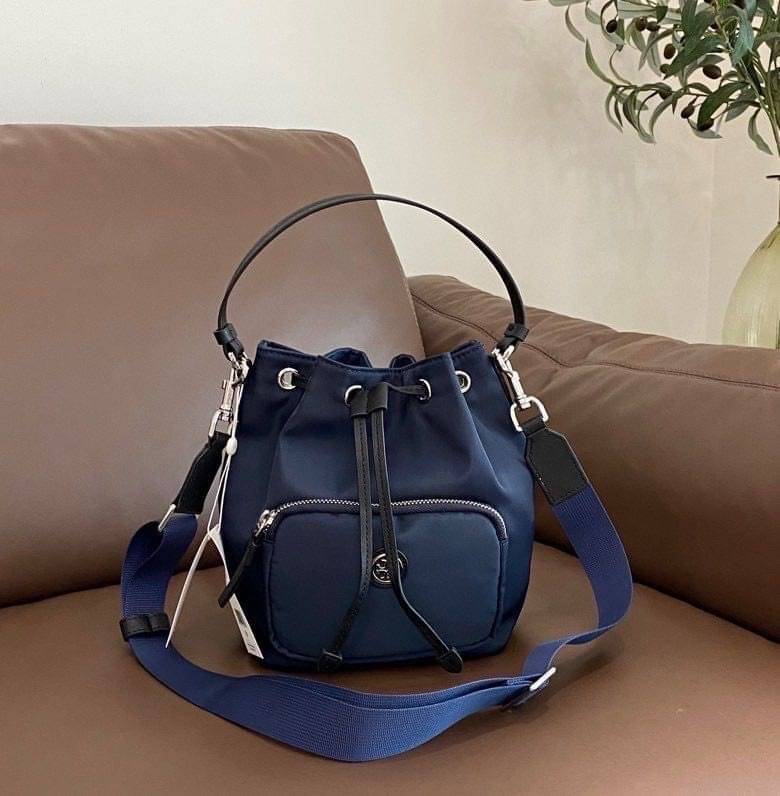 Tory Burch Virginia Nylon Bucket Bag / Tory Burch logo-plaque bucket bag กระเป๋าสะพายทรงบัคเก็ต เปิด-ปิดหนังรูดปากกระเป๋า มีหูหิ้วในตัว คล้องแขนเก๋ๆ ภายในเป็นช่องโล่ง มีช่องย่อย ใส่ของสำคัญจุกจิกได้ มีสายครอส จะสะพายไปไหนก็ได้ทุกโอกาส สวยเลิศทุกสี พร้อมส่