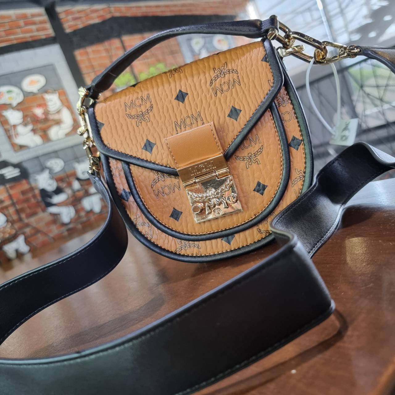 M.C.M MINI PATRICIA SHOULDER BAG IN VISETOS LEATHER BLOCK อัพเลเวลกระเป๋าของคุณด้วยไอเท็มนี้ไปเลยจ้า กระเป๋าสะพายทรง saddle ที่เก๋ไม่ซ้ำใคร ดีไซน์ขอบสีดำเพิ่มความยูนิค สวยสะดุดตา วัสดุหนังแคนวาสคุณภาพดี มาพร้อมสายสะพายหนังสีดำเรียบ และหูจับในตัว ทำให้ใช้ง