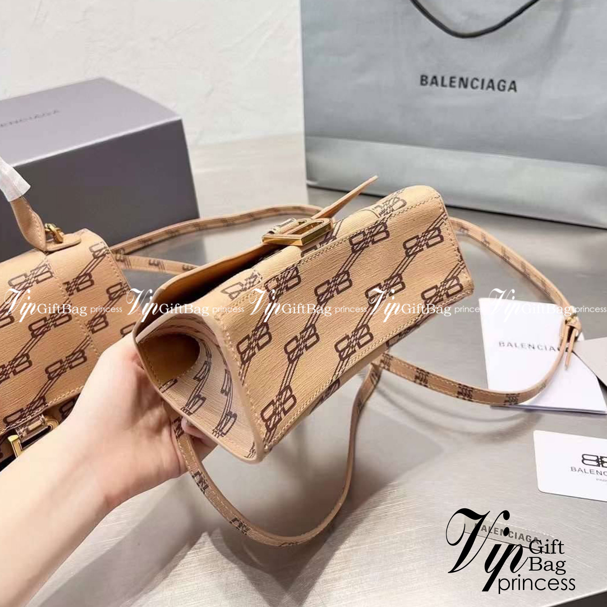 BALENCIAGA Hourglass BB Monogram top-handle tote bag กระเป๋าสะพายแบรนด์หรูซิกเนเจอร์ใบล่าสุด ที่มาพร้อมดีไซน์โดดเด่น มีความโฉบเฉี่ยว โค้งมนเหมือนพระจันทร์เสี้ยว เพิ่มความโดดเด่นสะดุดตาด้วยการตกแต่งอักษร B เมทัลลิก ที่เป็นเอกลักษณ์แบรนด์ งานจริงสวยงามตามรู