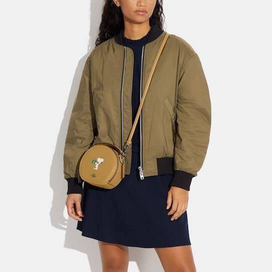 COACH X PEANUTS CANTEEN CROSSBODY WITH SNOOPY PRESENT MOTIF (CE845,CF290) กระเป๋าสะพายข้างทรงกลมไซส์มินิ มีหูจับ วัสหนังแท้ ด้านหน้าโดดเด่นด้วยรูปการ์ตูนSnoopy