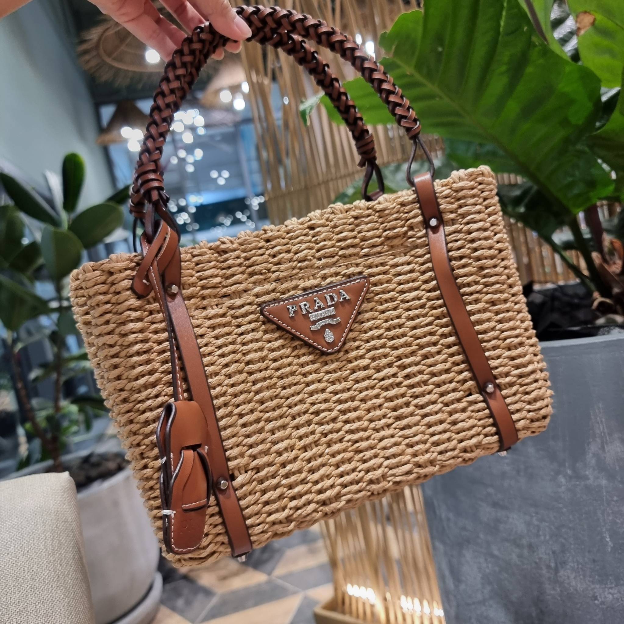 PRADA CORN HUSK AND LEATHER TOTE ธรรมชาติเป็นหนึ่ง!! กับอีกไอเท็มรักษ์โลก ด้วยดีไซน์ล้ำทันสมัย ผสานกับวัสดุจากธรรมชาติ ออกมาเป็นลายสานที่สวยหรู ไม่กระด้าง กระเป๋าทรงโท้ท ขนาดกำลังสวย มาพร้อมหูจับในตัว มีซิปรูปเปิด-ปิดที่ปากกระเป๋า ภายในโล่งกว้าง ใส่ของได้