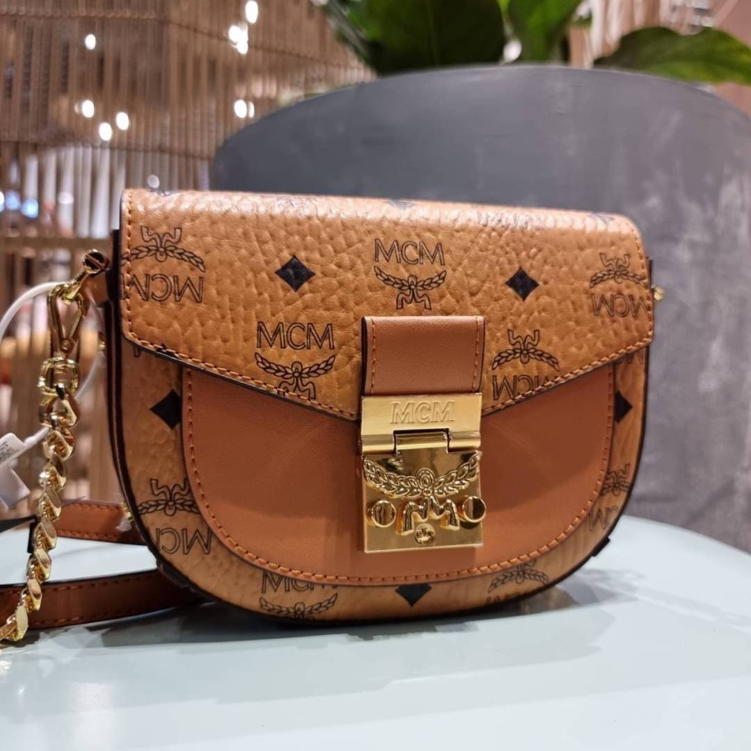 M.C.M MINI PATRICIA CROSSBODY IN VISETOS กระเป๋าสะพายไซส์มินิ แรงดีไม่มีตกน้า คอลเลคชั่นนี้ดีไซน์แปลกใหม่ ทรงโค้งมน สวยหรู ด้านข้างตกแต่งหมุดทองรอบใบ วัสดุตัวกระเป๋าเป็นหนังแคนวาสคุณภาพดี ภายในเป็นหนังกลับสีส้มโดดเด่นเป็นเอกลักษณ์ มีช่องใส่บัตรแยกให้ เปิด