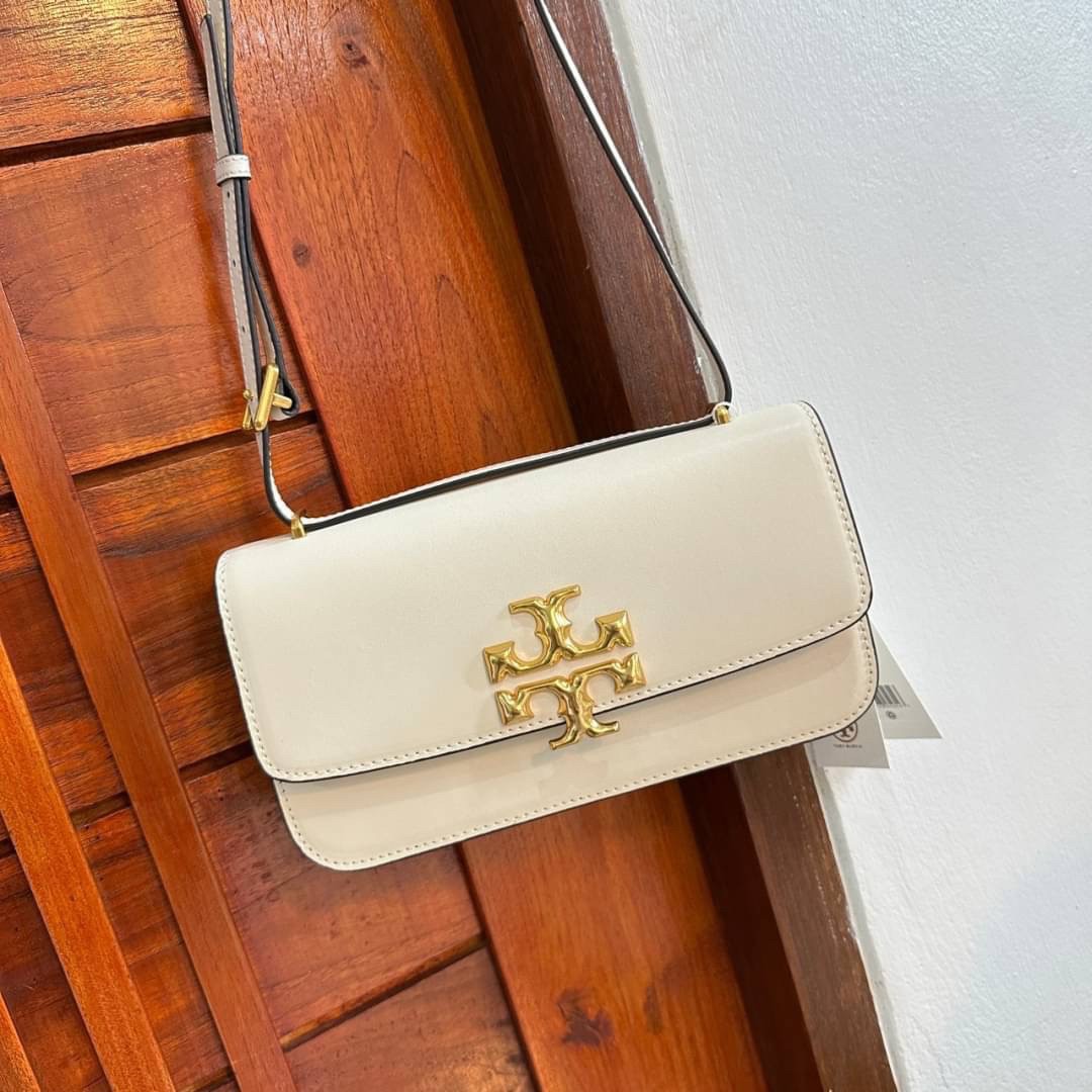 TORY BURCH ELEANOR SMALL LONG CONVERTIBLE SHOULDER กระเป๋าสะพายทรงยาว E/W Eleanor Convertible สูดหรู ดูแพง หนังแท้ เรียบสวยหรู โดดเด่นด้วยป้ายโลโก้สีทอง ลาย Double T อันเป็นเอกลักษณ์ ภายในช่องโล่งกว้างสามารถใส่โทรศัพท์ได้ทุกรุ่น สามารถใส่กระเป๋าสตางค์ใบยา