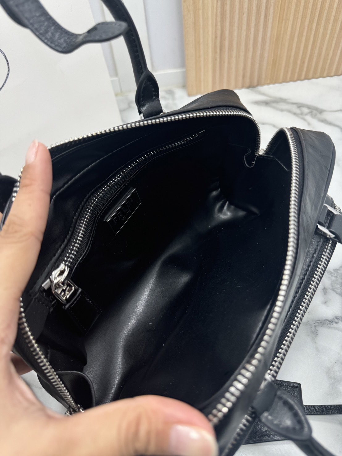 ORI หนังแท้ | Prada Antique nappa leather multi-pocket top-handle bag กระเป๋าสะพายทรง keepall มีช่องซิปด้านหน้าพร้อมหูจับ งานหนังยับดีไซน์เอฟเฟกต์เท็กซ์เจอร์ที่มีเสน่ห์สไตล์วินเทจ พร้อมทริกห้อยเพิ่มสไตล์สัมผัสที่โดดเด่นและร่วมสมัยยิ่งขึ้น