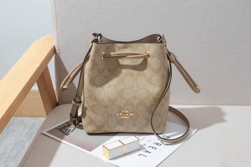 Coach Lena Crossbody Signature Bucket Bag กระเป๋าสะพายไหล่สุดคลาสสิกรุ่นนี้ เป็นรูปทรงถัง ที่สามารถจุของได้กำลังดี สำหรับสาวๆสายแฟชั่นที่ชอบรายละเอียดชิคๆ ดีไซน์เก๋ ด้วยรูปทรงของกระเป๋าที่ออกแบบมาให้ฐานเป็นรูปสี่เหลี่ยมทำให้กระเป๋ายังคงรูปทรงได้ง่าย มีสาย