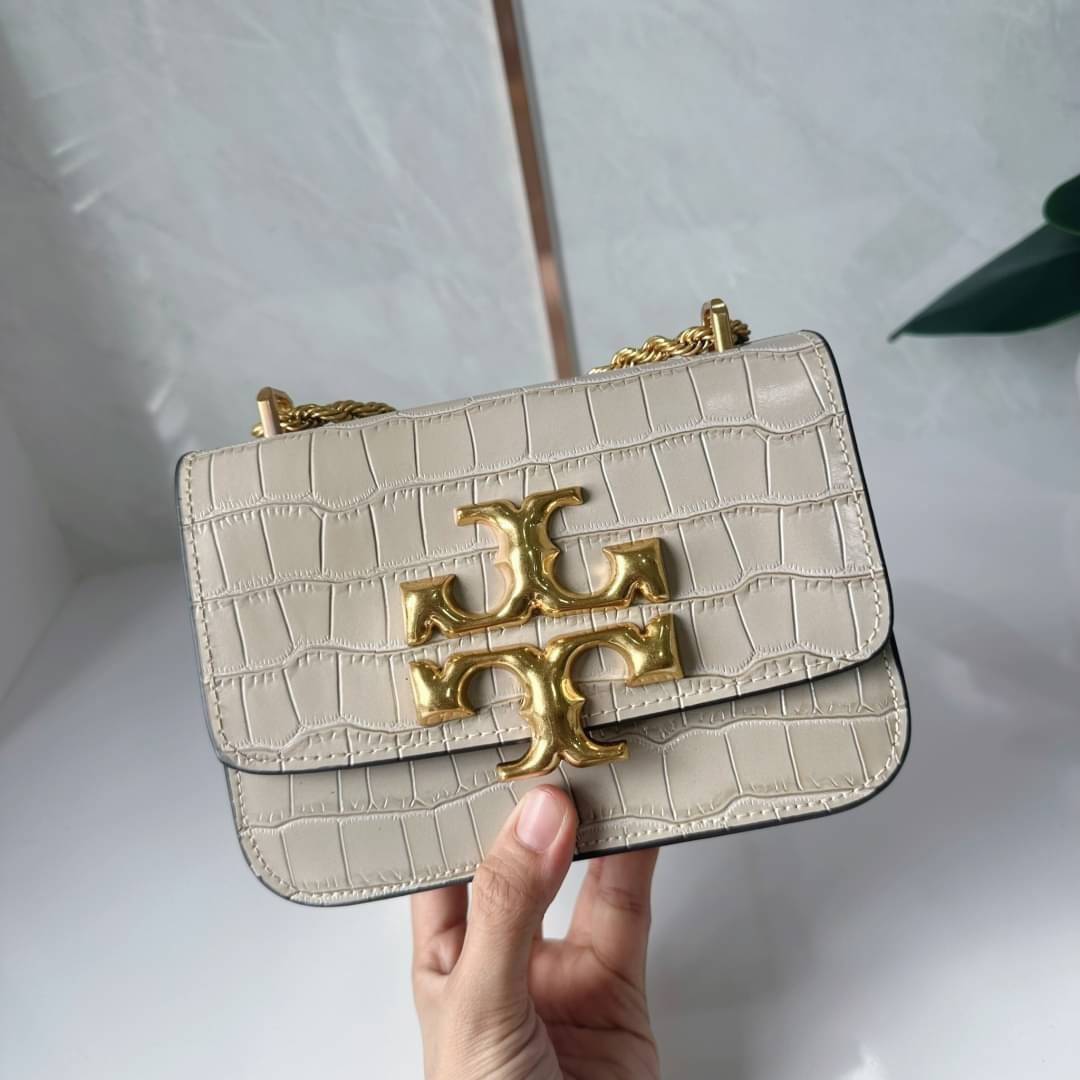 6 สี Tory Burch Croc Eleanor Small Bag / TORY BURCH ELEANOR CROC EMBOSSED LEATHER กระเป๋าสะพายหนังพิมพ์ลายจระเข้ ดีไซน์หรูหรา โด่นเด่นด้วยโลโก้แบรนด์อะไหล่ด้านหน้า และสายสะพายโลหะสีทอง
