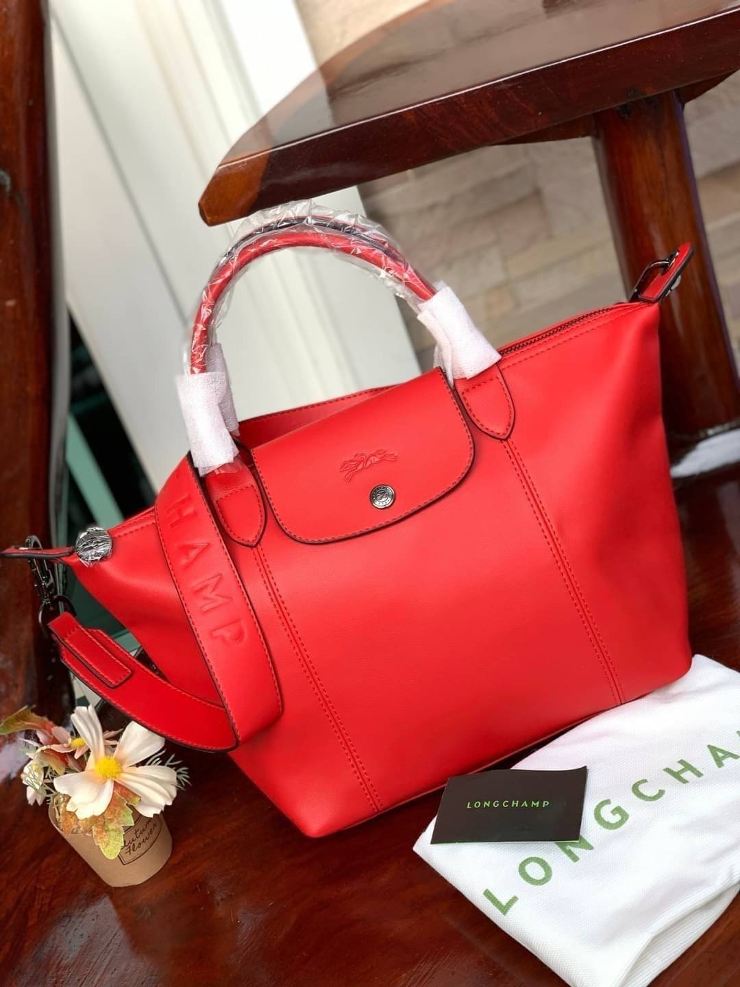 Longchamp LE PLIAGE CUIR TOP HANDLE BAG S เรียกว่าเป็นกระเป๋าอีกหนึ่งรุ่นที่ไม่ว่ายังไงก็ฮอตฮิตและติดเทรนด์ตลอดไม่เคยเปลี่ยนกับ ทรง Le Pliage Cuir หนึ่งในตระกูลกระเป๋าสุดไอคอนิกจากแบรนด์ เมื่อรุ่น Le Pliage Cuir ในรูปแบบของหนังแกะ Metis ได้ถือกำเนิดขึ้นใน