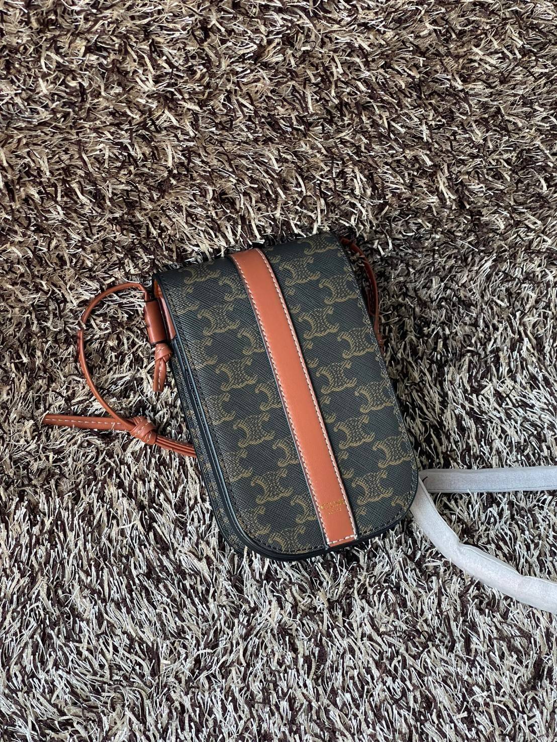 Celine Phone Pouch in Triomphe Canvas กระเป๋าใส่โทรศัพท์รุ่นนี้ มีดีไซน์ดูเรียบง่าย แต่ดูหรูหราด้วยลวดลาย Triompe ที่แสดงถึงความเป็นเอกลักษณ์ของ celine ช่องหลักที่มีความกว้าง สามารถใส่โทรศัพท์มือถือ ธนบัตร บัตรต่าง ๆ และของจุกจิกชิ้นเล็ก ๆ ได้แบบจุใจ หรือ