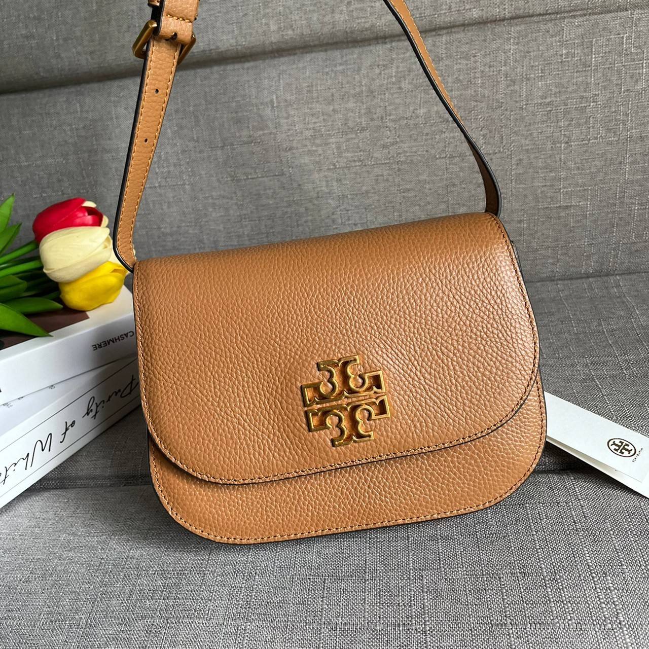 TORY BURCH BRLTTEN SMALL SADDLE BAG / Tory Burch Britten Flap Shoulder Bag กระเป๋าสะพายข้าง วัสดุหนังแกะแท้ ด้านหน้าประดับโลโก้แบรนด์ เปิด-ปิดกระเป๋าแบบกระดุมแป็กแม่เหล็กแน่นหนา ภายในมีช่องหลัก ใส่กระเป๋าเงินใบกลาง มือถือได้ทุกรุ่น มีช่องแยกใส่ของจุกจิกอี