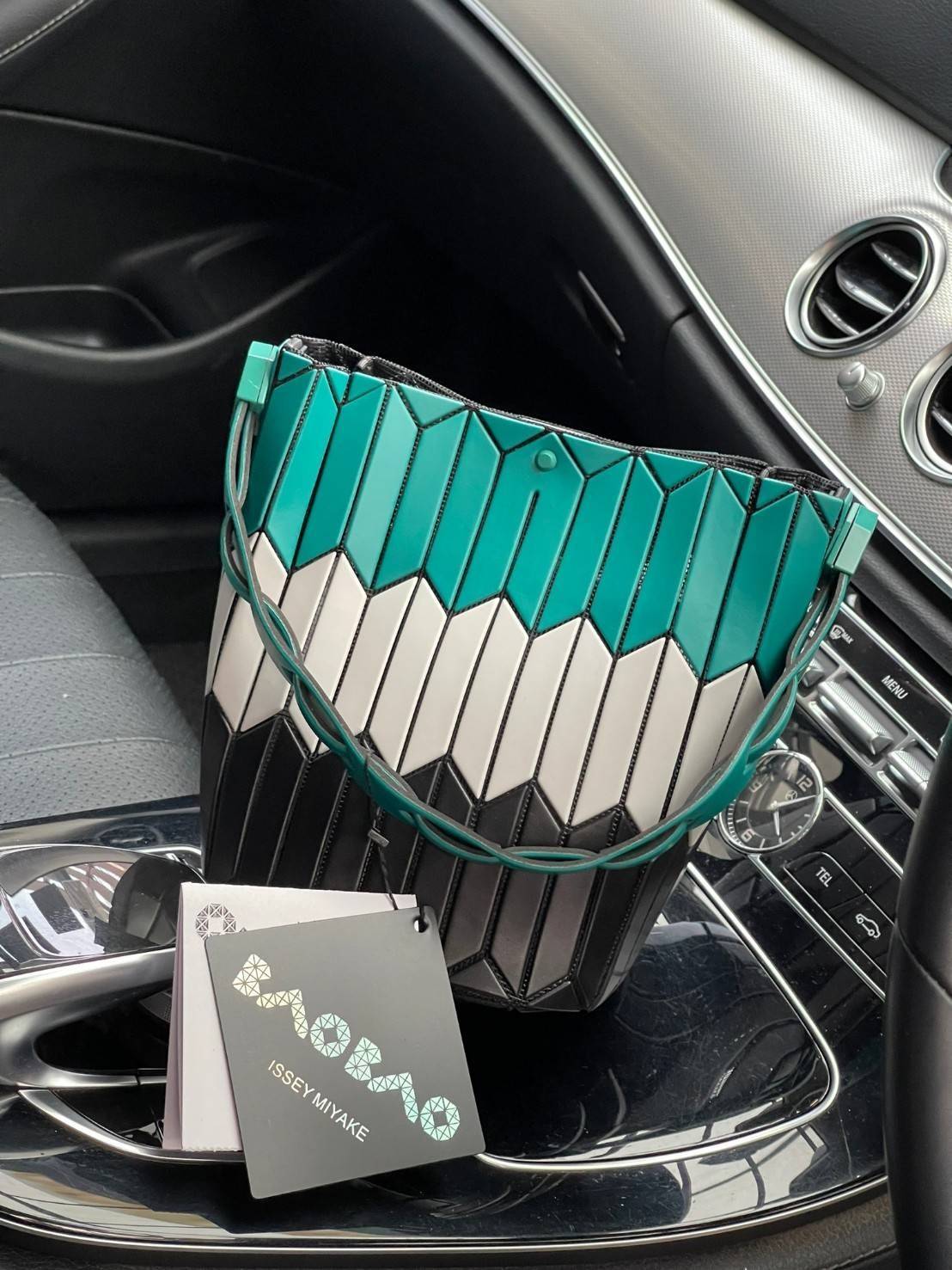 Small : BAO BAO ISSEY MIYAKE SMALL BUCKET เป็นกระเป๋าบัคเก็ตขนาดเล็กสามารถใช้ใส่กระเป๋าสตางค์และโทรศัพท์มือถือได้ ซีรีย์ใหม่นี้มีจุดเด่นที่แผ่นรูปทรงสี่เหลี่ยมด้านขนานในแนวตั้ง เกิดเป็นรูปทรงสามมิติซึ่งแตกต่างไปจากรูปทรงที่เกิดขึ้นจากแผ่นสามเหลี่ยม หูหิ้ว