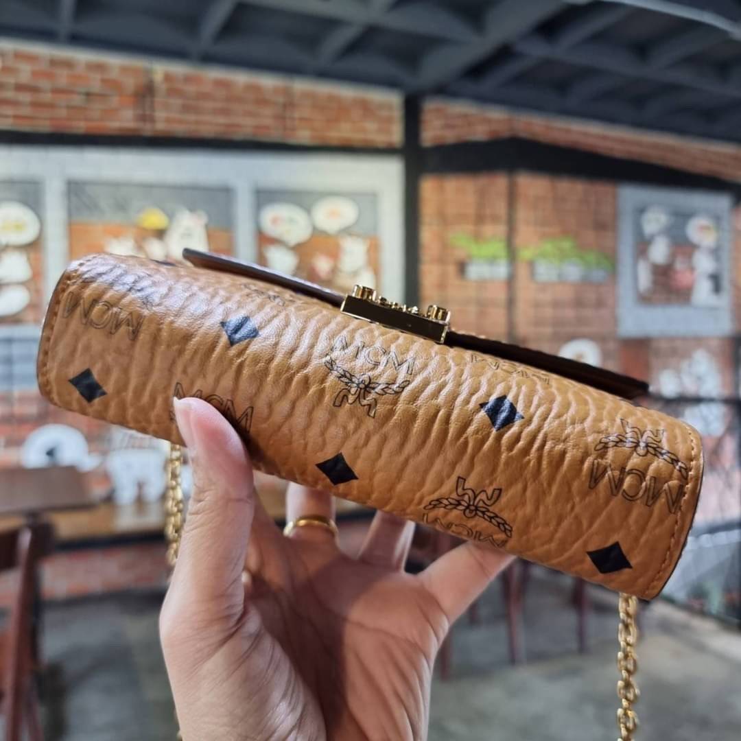 M.C.M SMALL MILLIE FLAP CROSSBODY IN VISETOS ไซส์ใหม่พกพาสะดวก!! กระเป๋าสะพายกึ่งคลัทช์ รอบนี้มาไซส์สวย สามารถใช้แทนกระเป๋าสตางค์ได้เลย ใส่โทรศัพท์มือถือได้ทุกรุ่น ใส่ของสำคัญสบายๆ มาพร้อมสายสะพายโซ่สีทองหรูหรา รูปทรงดีไซน์ร่วมสมัย ใช้งานง่ายด้วยตัวล็อค ว