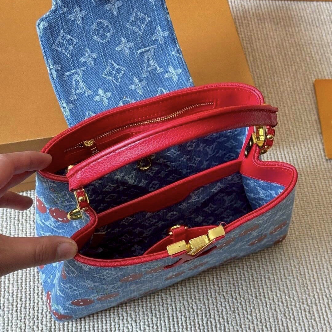 LV Capucines Monogram cherry denim กระเป๋าถือสุดหรูรูปทรงสวยคลาสสิกมาพร้อมหูจับในตัว สวยคมสะกดทุกสายตา ที่สุดของความสวยในราคาเบาๆ โดดเด่นมีชีวิตชีวา ด้วยเดนิมวินเทจปักลายเชอร์รี่สีสันสดใสสะดุดตาสะท้อนสไตล์ไอคอนิก