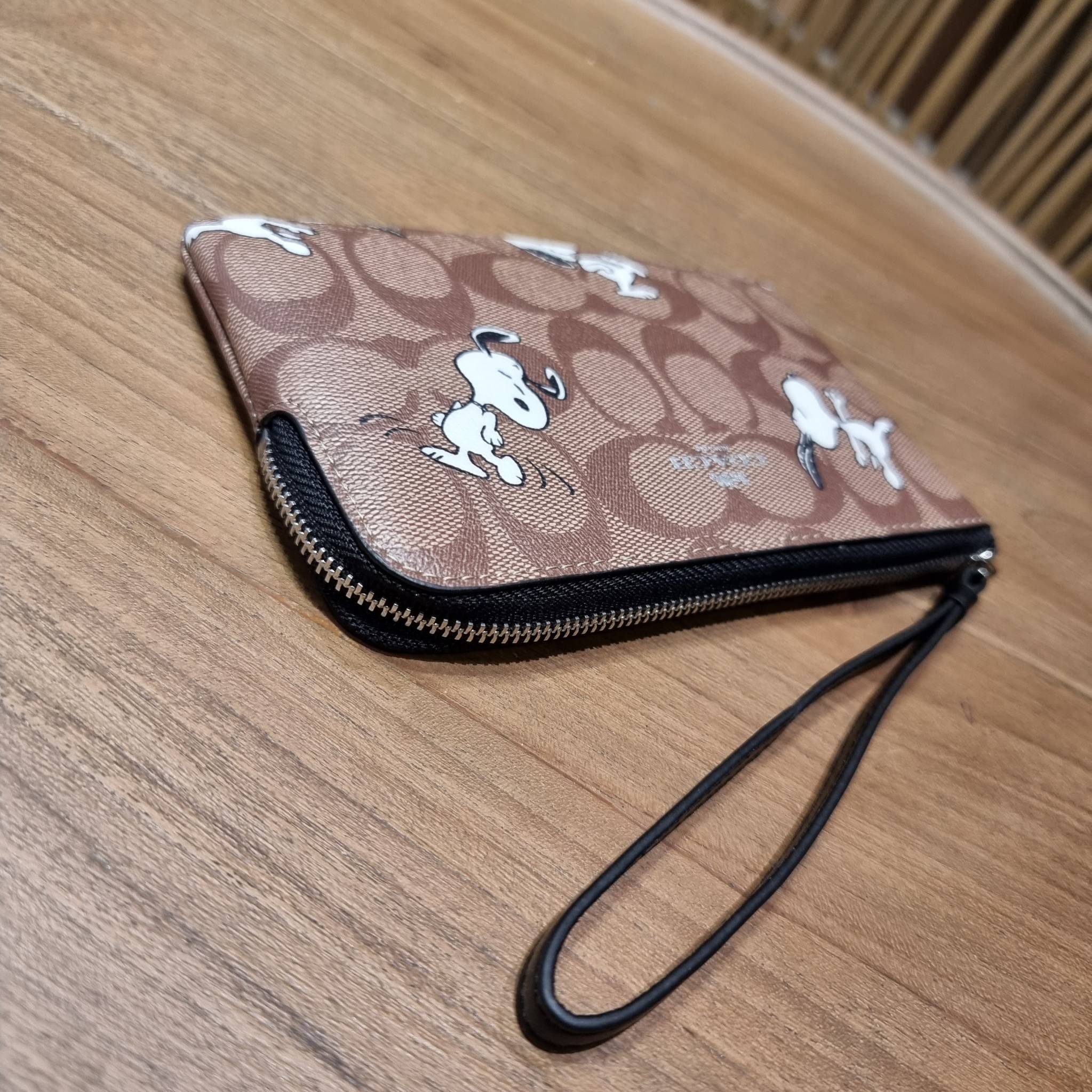 COACH C4589 COACH x PEANUTS CORNER ZIP WRISTLET IN SIGNATURE CANVAS WITH SNOOPY PRINT เหล่าผองเพื่อนและสนูปพีมาแล้วจ้า คอลเลคชั่นสุดน่ารักที่ฮอตไม่มีตก กระเป๋าคล้องมือ ขนาดเหมาะพกพากำลังเหมาะ วัสดุหนังแคนวาสเคลือบลาย ภายในเป็นช่องโล่ง ใส่ธนบัตร หรือใส่บัต