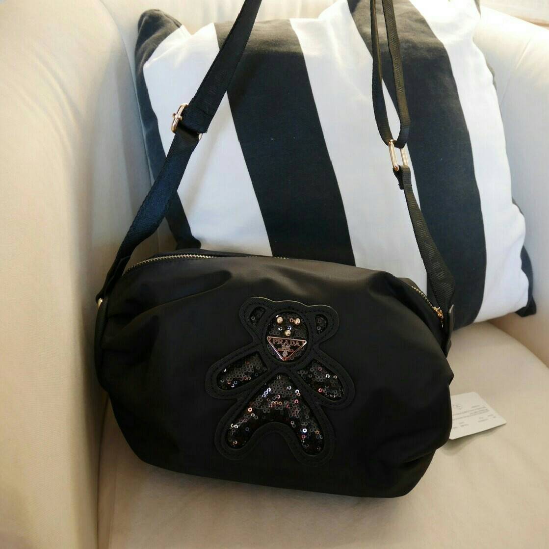 มาแล้วค้า! PRADA NYLON CROSSBODY BAG กระเป๋าสะพายพรีเมี่ยมกิ้ฟจากเคาน์เตอร์ต่างประเทศ Limited edition วัสดุ Nylon เนื้อหนาคุณภาพดีตามแบบฉบับแบรนด์ ขนาดใหญ่ จุได้เยอะ น้ำหนักเบา ด้านหน้าเป็นลายหมีปั๊กกลิ้ตเตอร์โลโก้แบรนด์อะไหล่ทองหรู ภายในซับ Polyester 100
