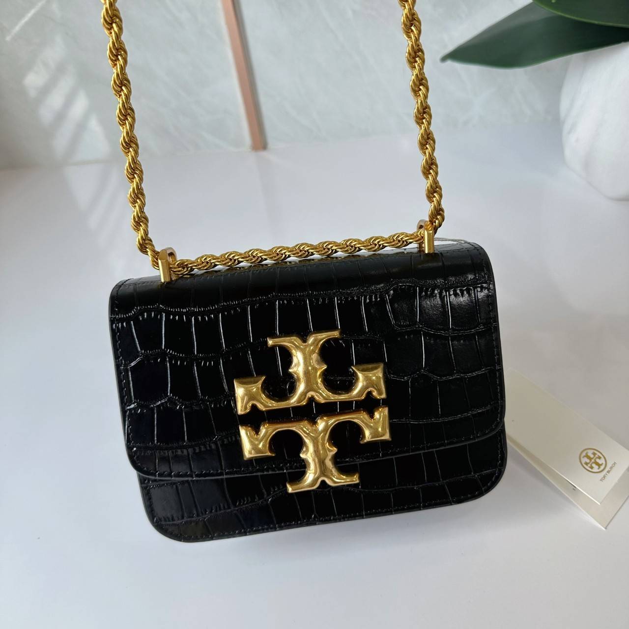 6 สี Tory Burch Croc Eleanor Small Bag / TORY BURCH ELEANOR CROC EMBOSSED LEATHER กระเป๋าสะพายหนังพิมพ์ลายจระเข้ ดีไซน์หรูหรา โด่นเด่นด้วยโลโก้แบรนด์อะไหล่ด้านหน้า และสายสะพายโลหะสีทอง