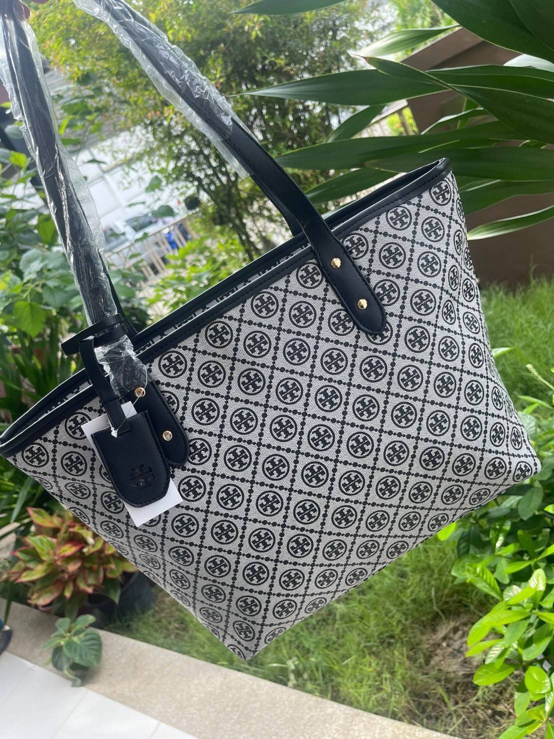 OUTLET 】Tory burch T Monograme Large shopping bag กระเป๋าสะพายใบไหล่ใบใหญ่ โดยตัวกระเป๋าทำมาจากผ้าแคนวาสเคลือบผิวด้านทนต่อรอยขีดข่วนได้เป็นอย่างดี ขนาดที่ใหญ่สามารถใส่ได้ทั้งเอกสารและสัมภาระต่างๆ พร้อมด้วยซิปปิดกระเป๋าด้านบนจึงเป็นอีกรุ่นที่เหมาะกับสาวออฟ