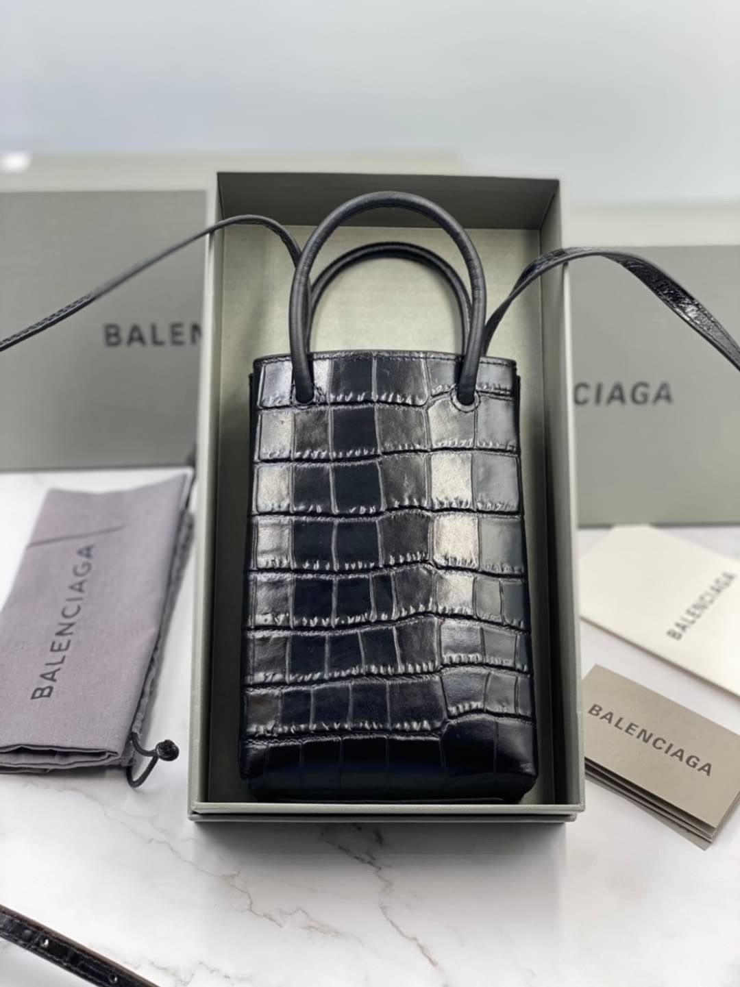 หนังแท้ BALENCIAGA Shopping Phone Pouch leather tote พกกระเป๋าช้อปปิ้งขนาดมินิ ไปทุกที่ในฤดูกาลนี้ ดีไซน์ที่ใช้ได้ทุกวันตั้งแต่หนังแบบมีเท็กซ์เจอร์ ภาพสินค้าถ่ายจากงานขายจริง ใช้งานต่างประเทศได้