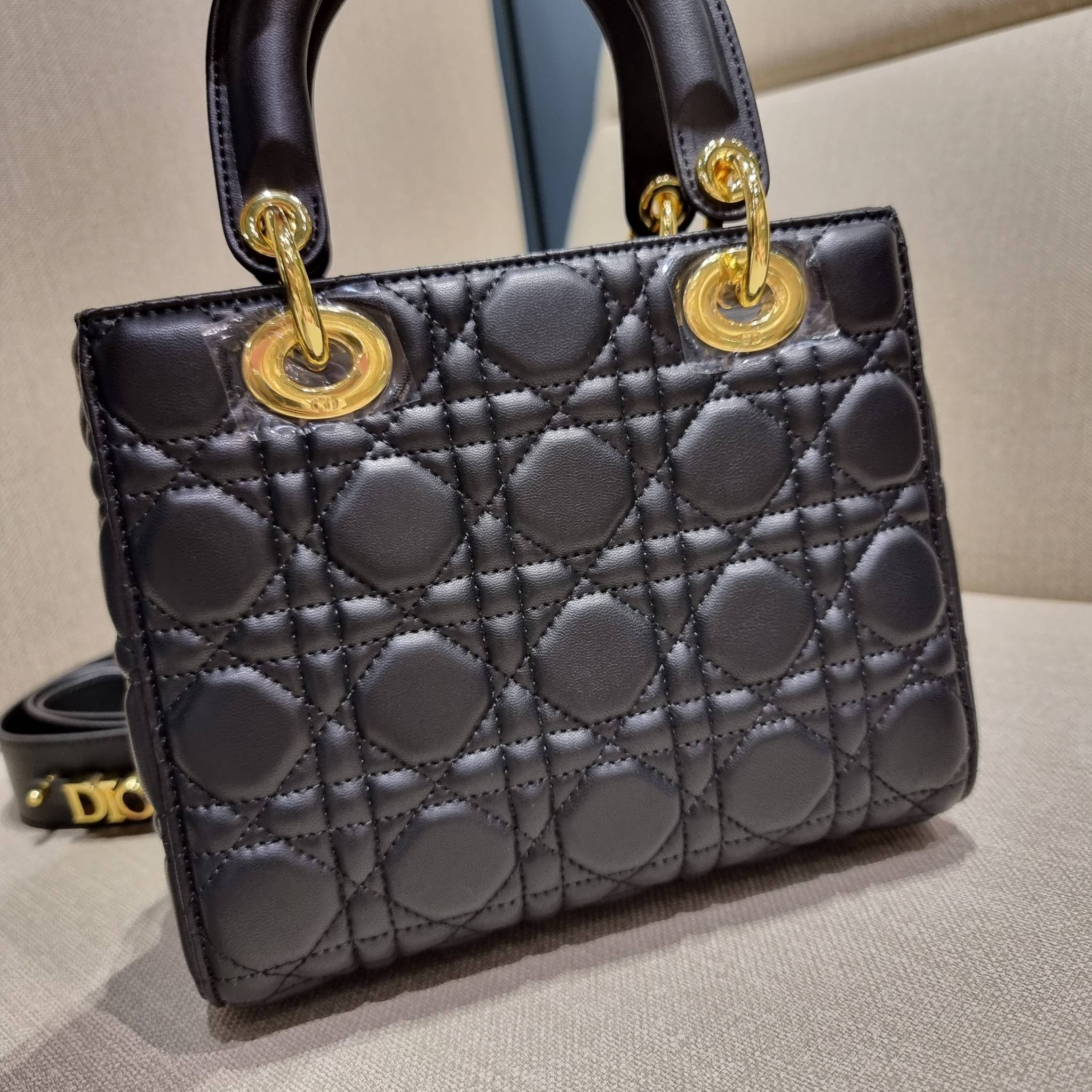 DIOR CD LADY BAG กระเป๋าสะพายข้างพรีเมี่ยมกิ๊ฟสุดฮอต ดีไซน์เรียบง่าย แต่แฝงไปด้วยความหรูหรา ทรงกล่องคลาสสิค โดดเด่นด้วยพวงกุญแจอะไหล่สีทอง วัสดุหนังแท้ มีหูจับในตัวและสายครอสบอดี้สุดเลิศ ที่มาพร้อมอะไหล่ฟอนท์สีทองเรียงร้อยในสายหนัง แต่งเติมดีเทลอัพราคาไปอ