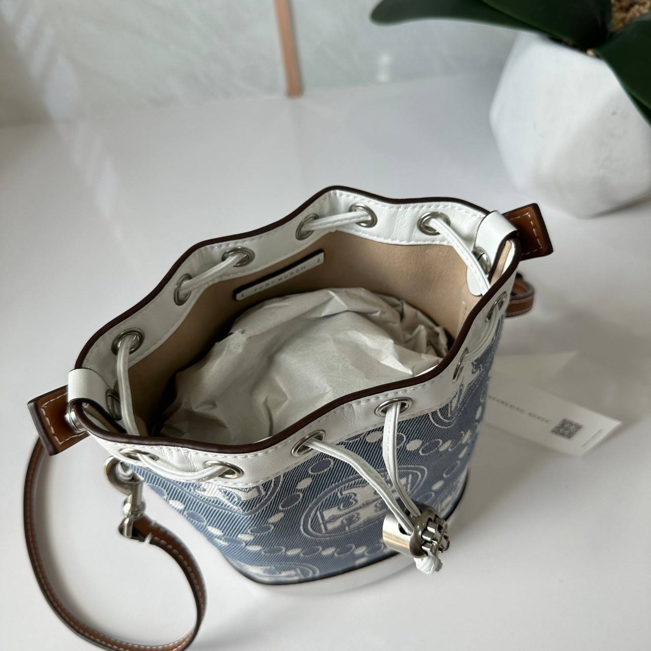 TORY BURCH Mini T Monogram Denim Bucket Bag คอลเลคชั่นใหม่ รูปแบบคลาสสิค พกพาความหรูหราไปได้ทุกที่ด้วยกระเป๋าทรง Bucket ขนาดกลางและปิดด้วยเชือกรูดพร้อมโลโก้แวววาว วัสดุผ้าเดนิมแจ็คการ์ด ตัดขอบหนังแท้ สวยหรู ทันสมัยสุดๆคะ