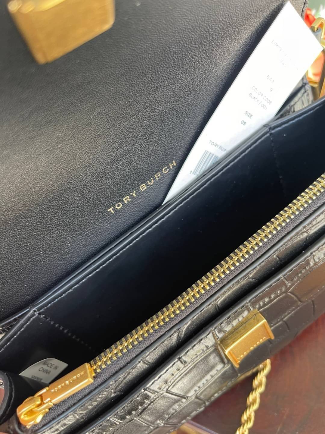 Tory Burch Eleanor Crocodile-Embossed Phone Crossbody Bag จุดเด่นของรุ่นนี้คือดีไซน์ออกมาในสไตล์คลาสสิกที่มาพร้อมกับฮาร์ดแวร์ที่ทำจากวัสดุทองเหลืองและสายสะพายโซ่เกลียวสีทอง ซึ่งการออกแบบได้รับแรงบันดาลใจมาจากเครื่องประดับ รูปทรงกะทัดรัดจึงสามารถสะพายใช้งา