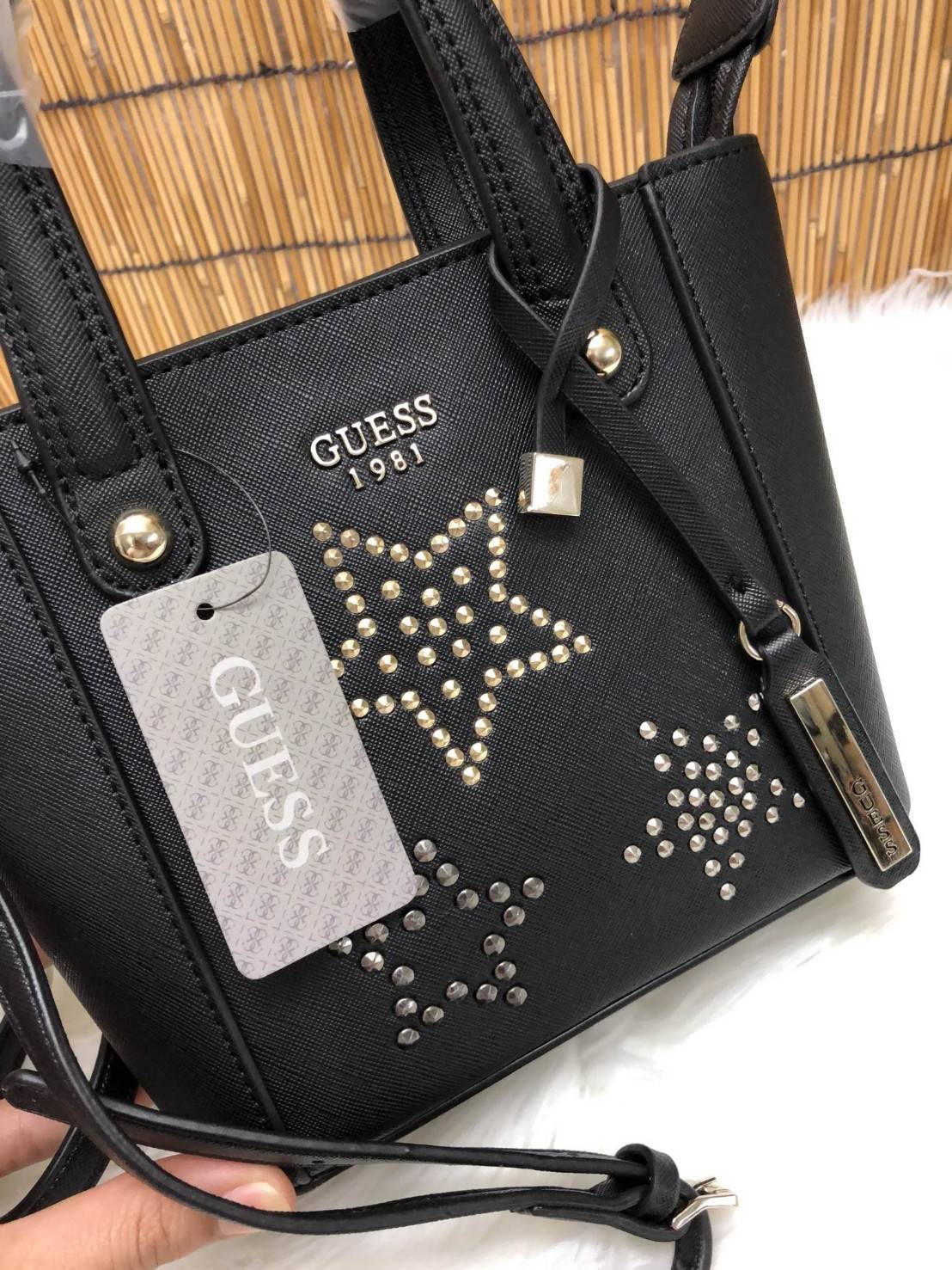 GUESS DELANEY MINI CROSSBODY BAG กระเป๋าถือหรือสะพายข้างได้ วัสดุหนังลาย saffiano ด้านหน้ามีโลโก้แบรนด์ พร้อมตกแต่งรูปดาว และ tag brand ห้อยที่หูกระเป๋า ตัวกระเป๋าเปิดแบบซิป ภายในโล่ง จุได้พอประมาณค่ะ มีช่องซิปอและช่องเล็ก มาพร้อม สายยาวปรับระดับได้ ราคาส