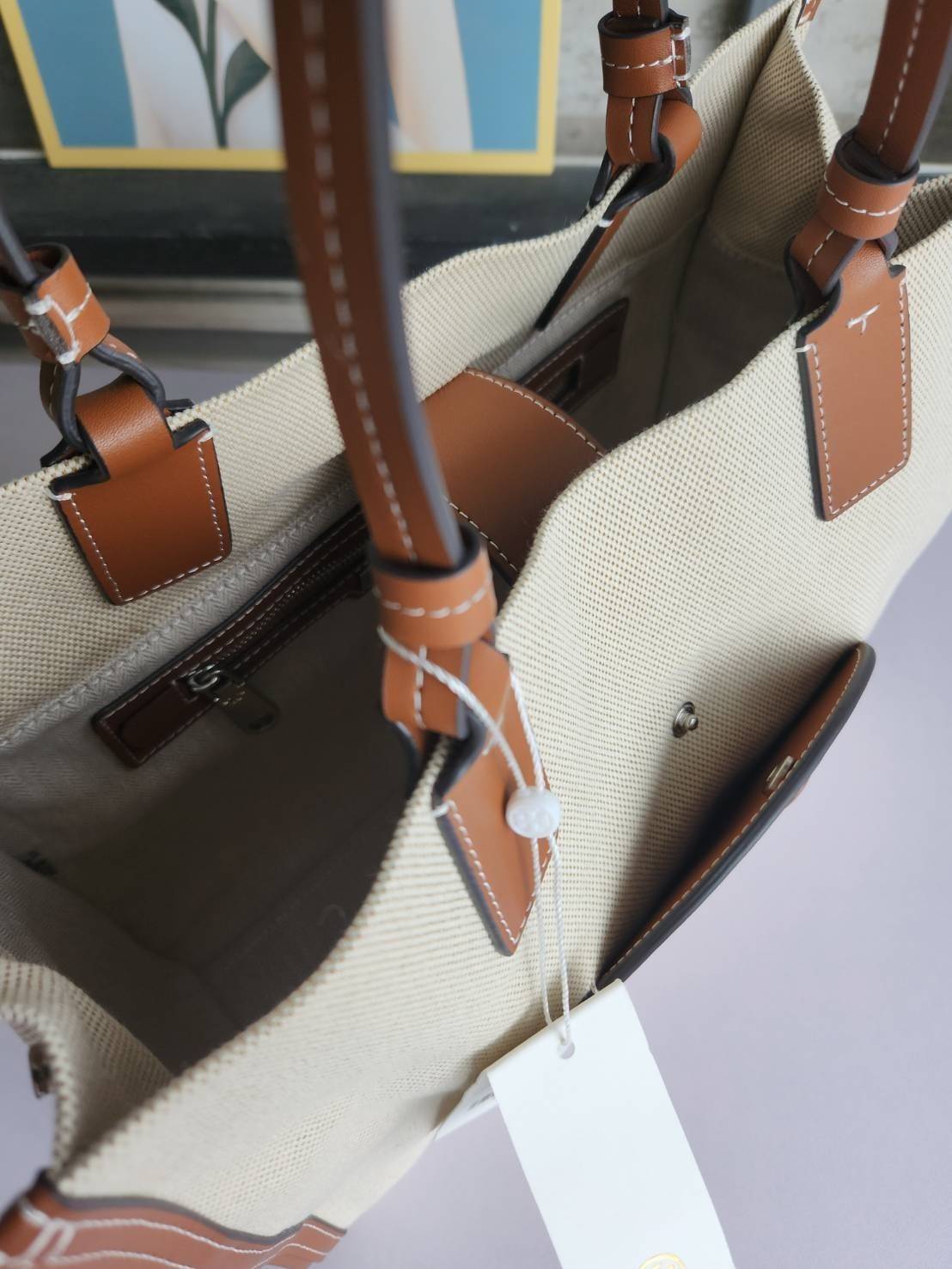 TORY BURCH ELLA CANVAS TOTE BAG กระเป๋าโท้ตน้ำหนักเบาของเราพร้อมป้ายโลโก้ Ella ทำจากผ้าใบที่ทนทานพร้อมรายละเอียดหนังและกระเป๋าด้านใน อเนกประสงค์ ทรงคลาสสิก และสร้างขึ้นอย่างสวยงามด้วยฝีมือช่างฝีมือ สายรัดแคบช่วยให้วางราบกับไหล่ได้อย่างสบาย เหมาะสำหรับทุกว