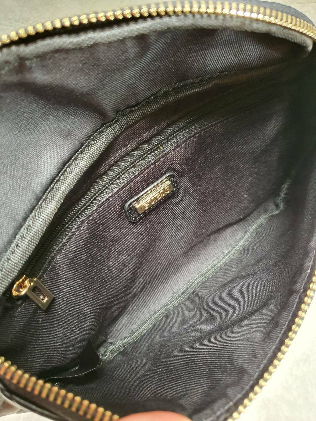 กระเป๋า Guess รุ่นนี้คาดเอว/คาดอก/สะพายข้างได้ครบทุกฟังก์ชั่น ด้านหน้าหนังเป็นลายตาราง ติดโลโก้แบรนด์รูปสามเหลี่ยมด้านหน้า เปิดปิดด้วยซิปยาว ด้านในเป็นช่องกว้างมีช่องซิปด้านใน ตัวกระเป๋าด้านหลังเป็นหนังเรียบ รุ่นนี้มีสายสะพายมา 2 เส้น เส้นแรกเป็นสายหนังปร