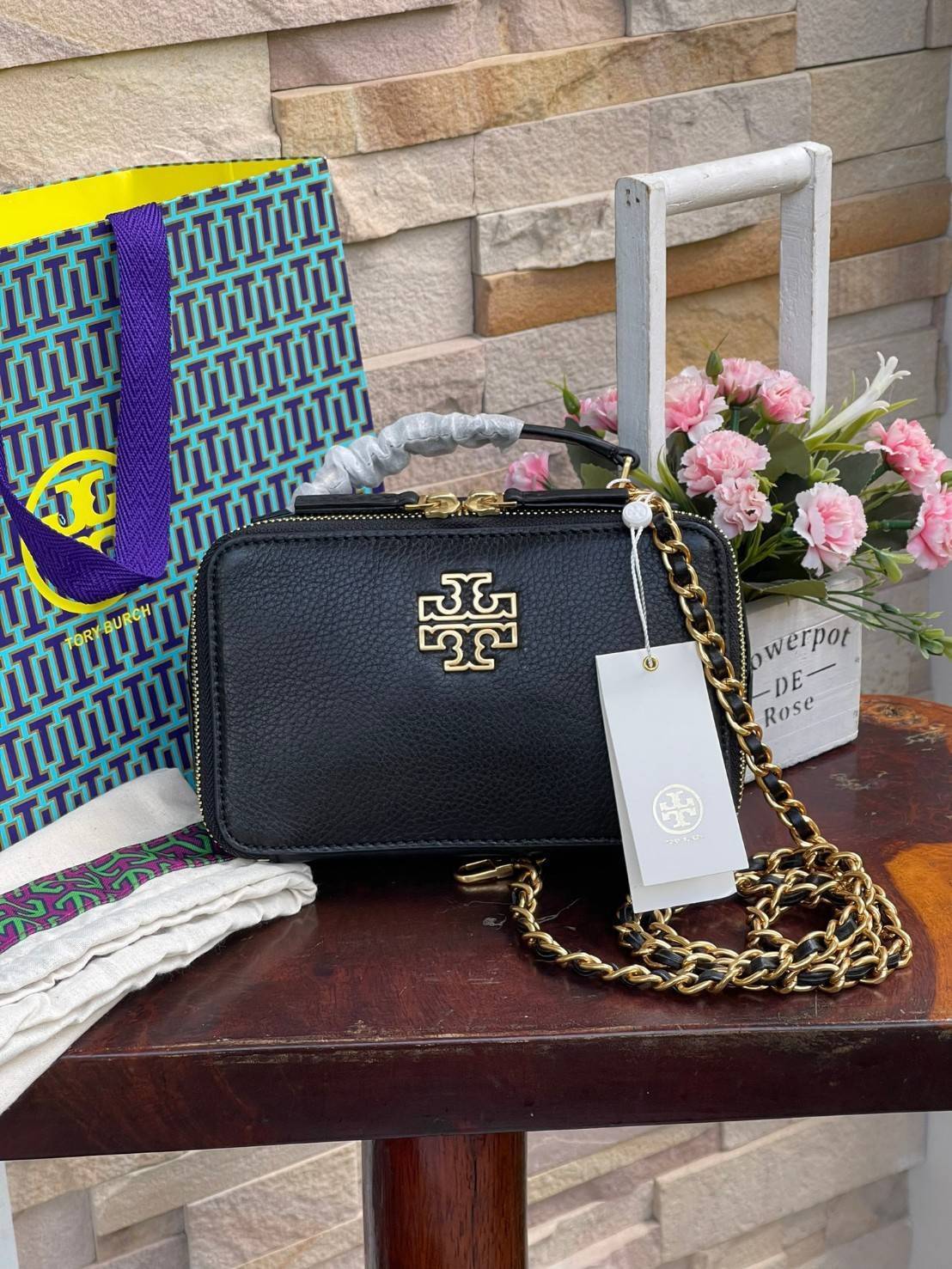 Tory burch Top Handle Case (84710) Collection ใหม่ที่เพิ่งเปิดตัวไปไม่นานจุดเด่นของรุ่นนี้คือดีไซน์ออกมาในสไตล์คลาสสิกที่มาพร้อมกับฮาร์ดแวร์ที่ทำจากวัสดุทองเหลืองและสายสะพายโซ่และหนัง ปากกระเป๋าเปิดได้กว้างแบบสองซิป รูปทรงสามารถสะพายใช้งานได้หลายโอกาส ไม่